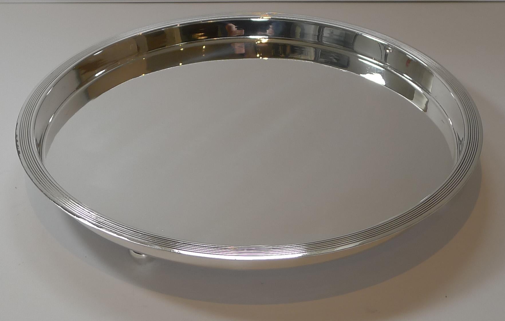 A wonderful Christofle cocktail / serving tray standing on four original ball feet; a very simple circular form with a linear decoration to the border; very reminiscent of the Ondulations design by Luc Lanel for Christofle.

Fully marked on the