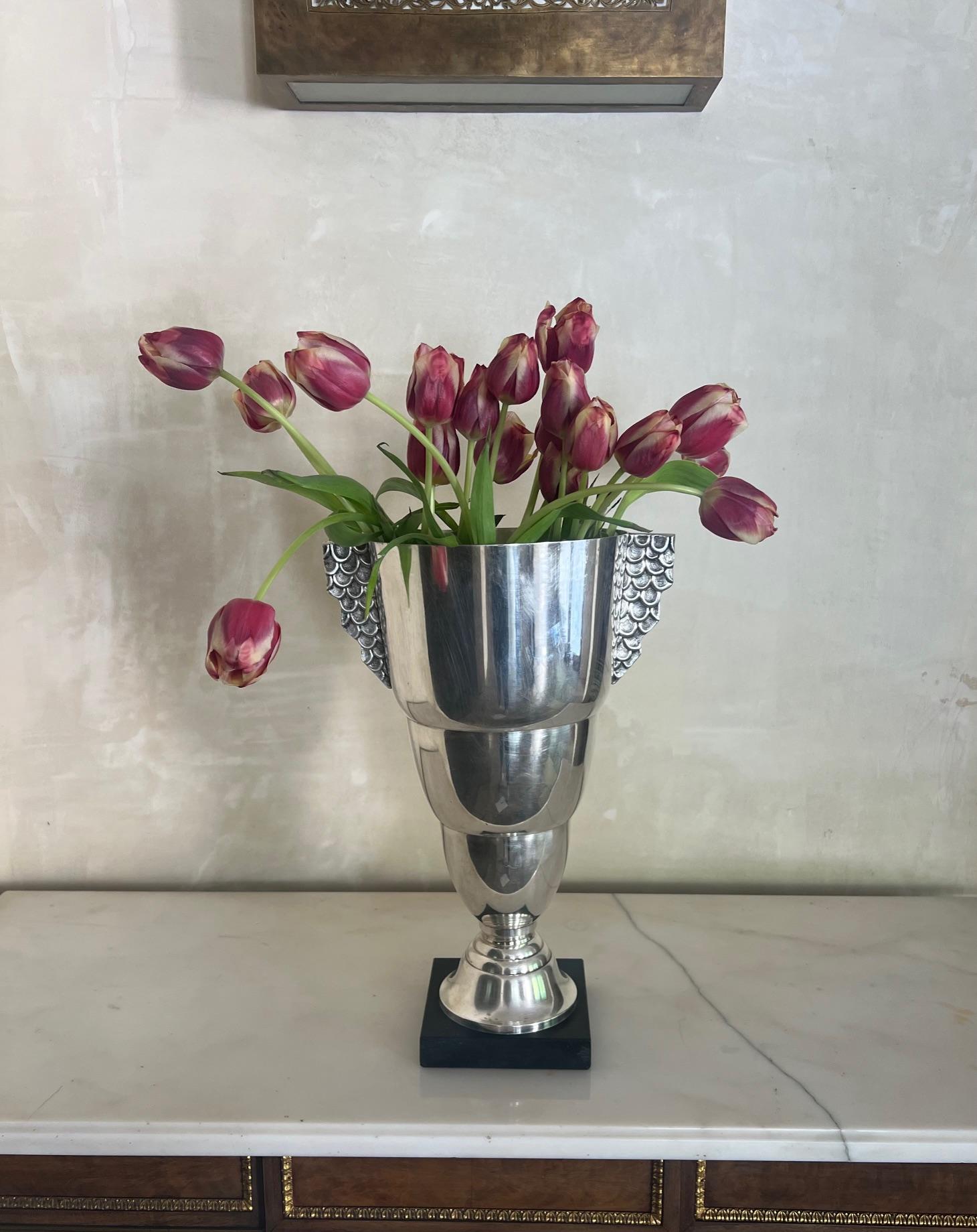 Grande vaso trofeo realizzato in Francia intorno agli anni '30. Il vaso poggia su un quadrato di marmo nero e i lati si estendono come ali. 
