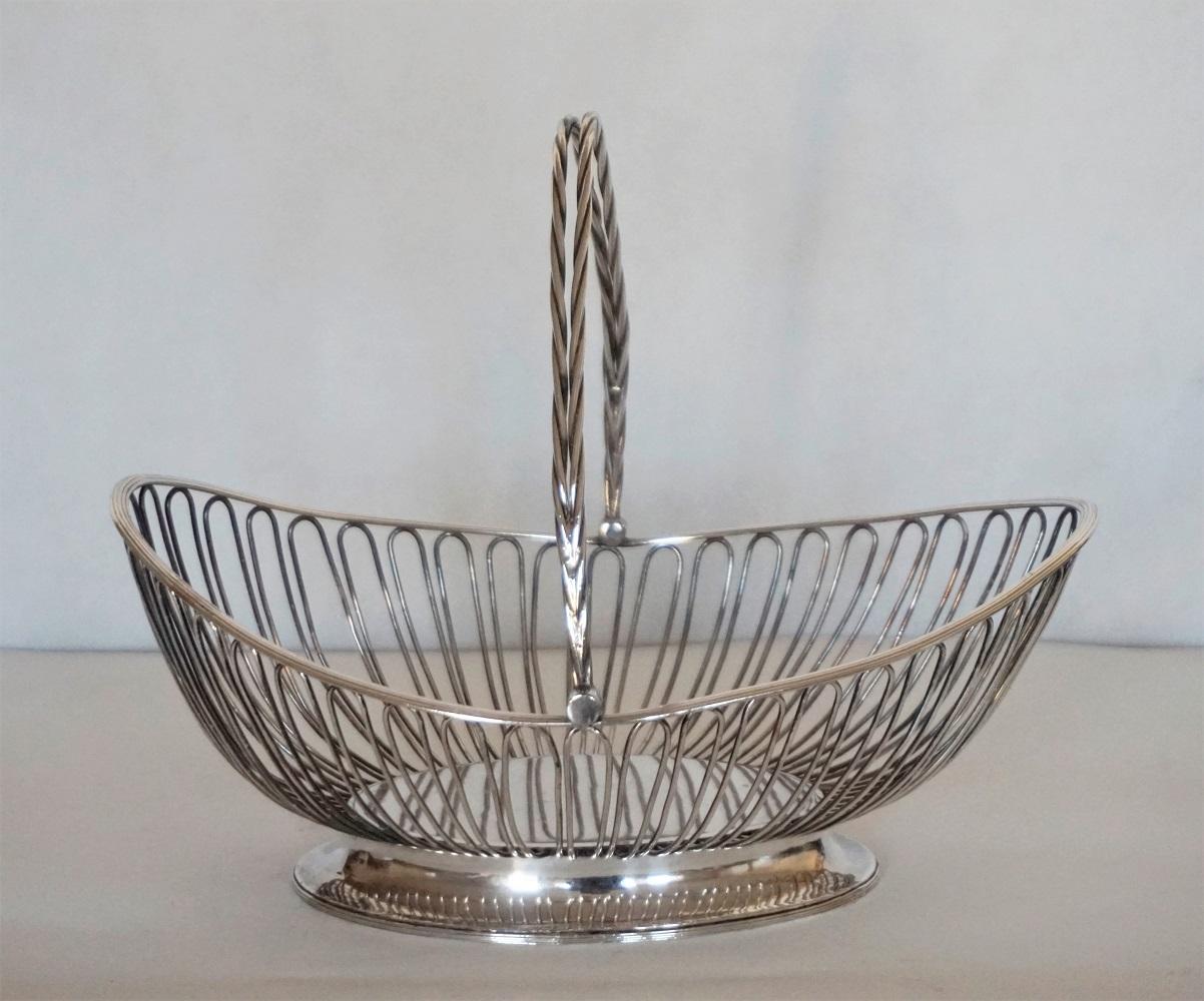 Art Deco silver plated metal serving basket with double braided swing handle, on a solid oval base, France, 1920-1929.
The basket has a oval rounded form in boat shape. This lovely piece can be used to serve bread or candy as well as a fruit