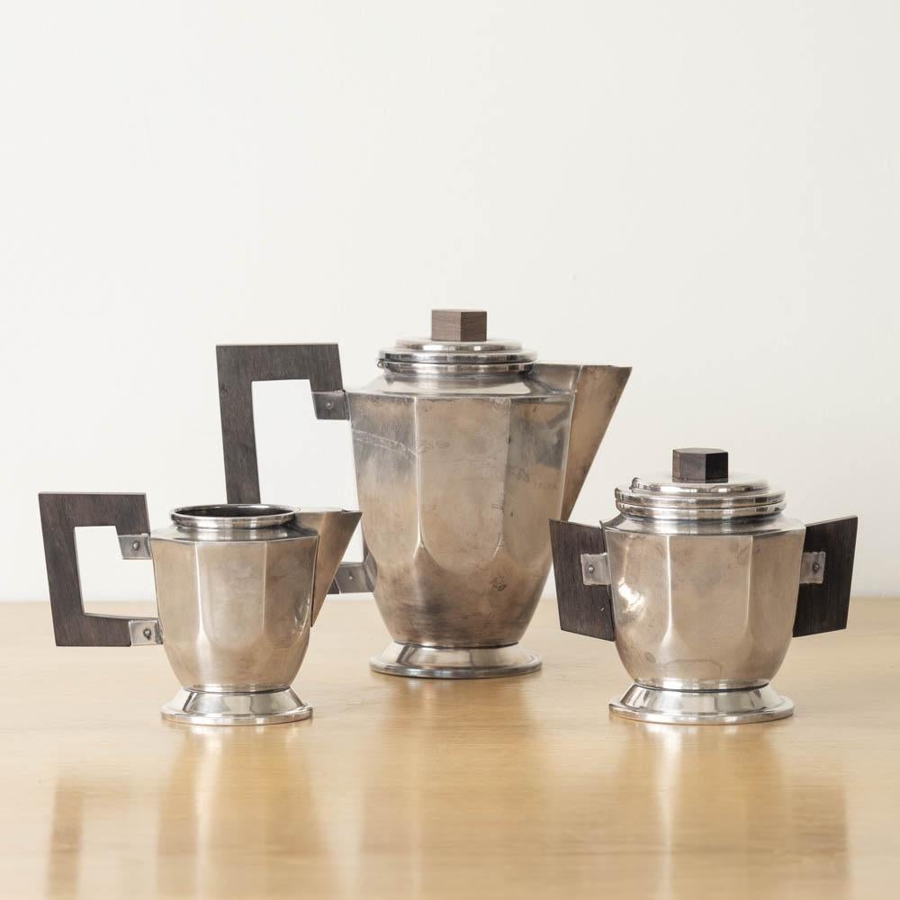 Unique Art Deco silver plate tea set made from France, 1930s. Heavy silver plate with wood handle detail. Set includes 1x tea pot with lid, 1x sugar bowl with lid, and 1x creamer bowl. Original finish shows nice age and patina. Stamped on the