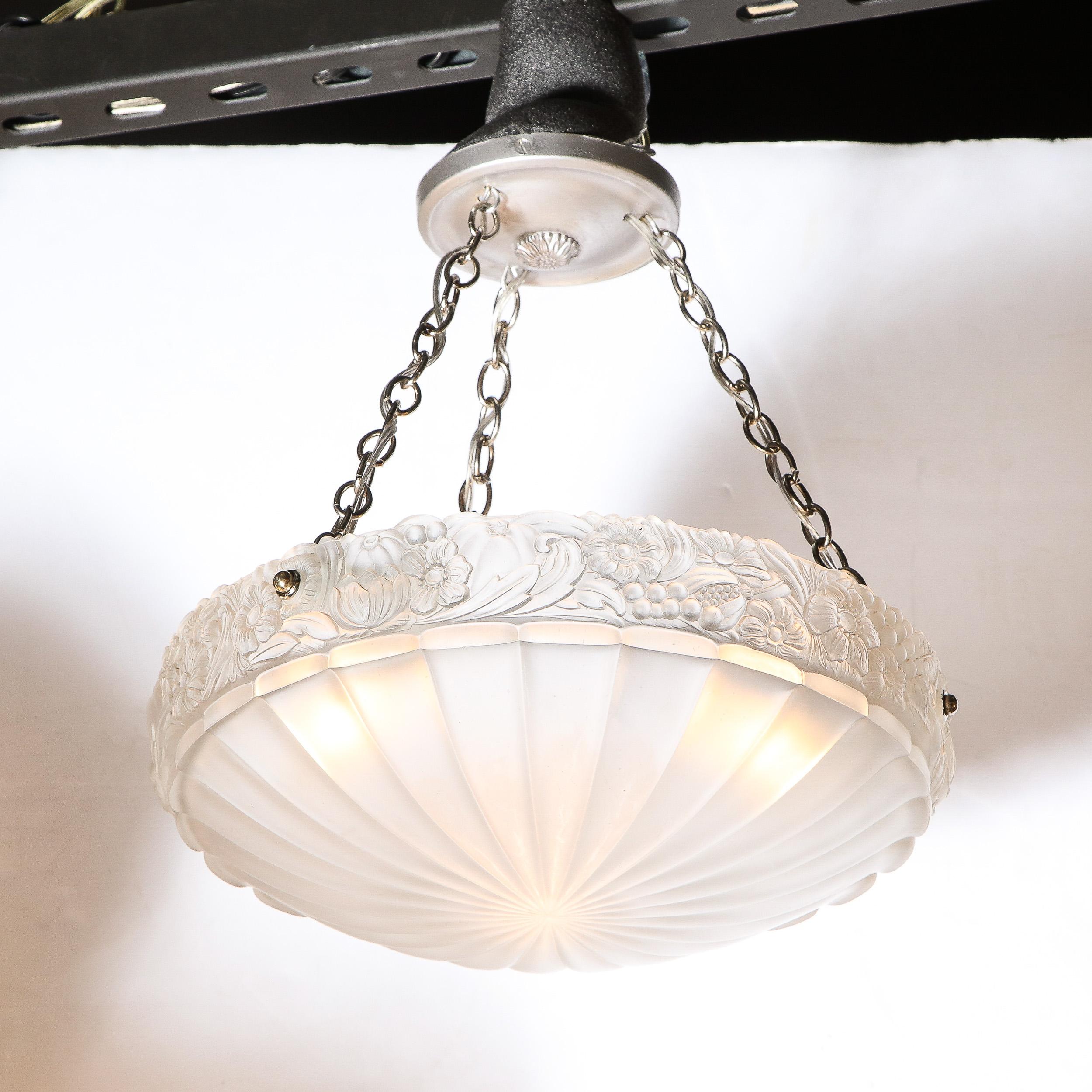 This stunning Art Deco chandelier was realized in France circa 1930. It features a concave domed shade with a channeled starburst bottom composed of an abundance of rays emanating outward from a central point. The glass sides of the shades have been