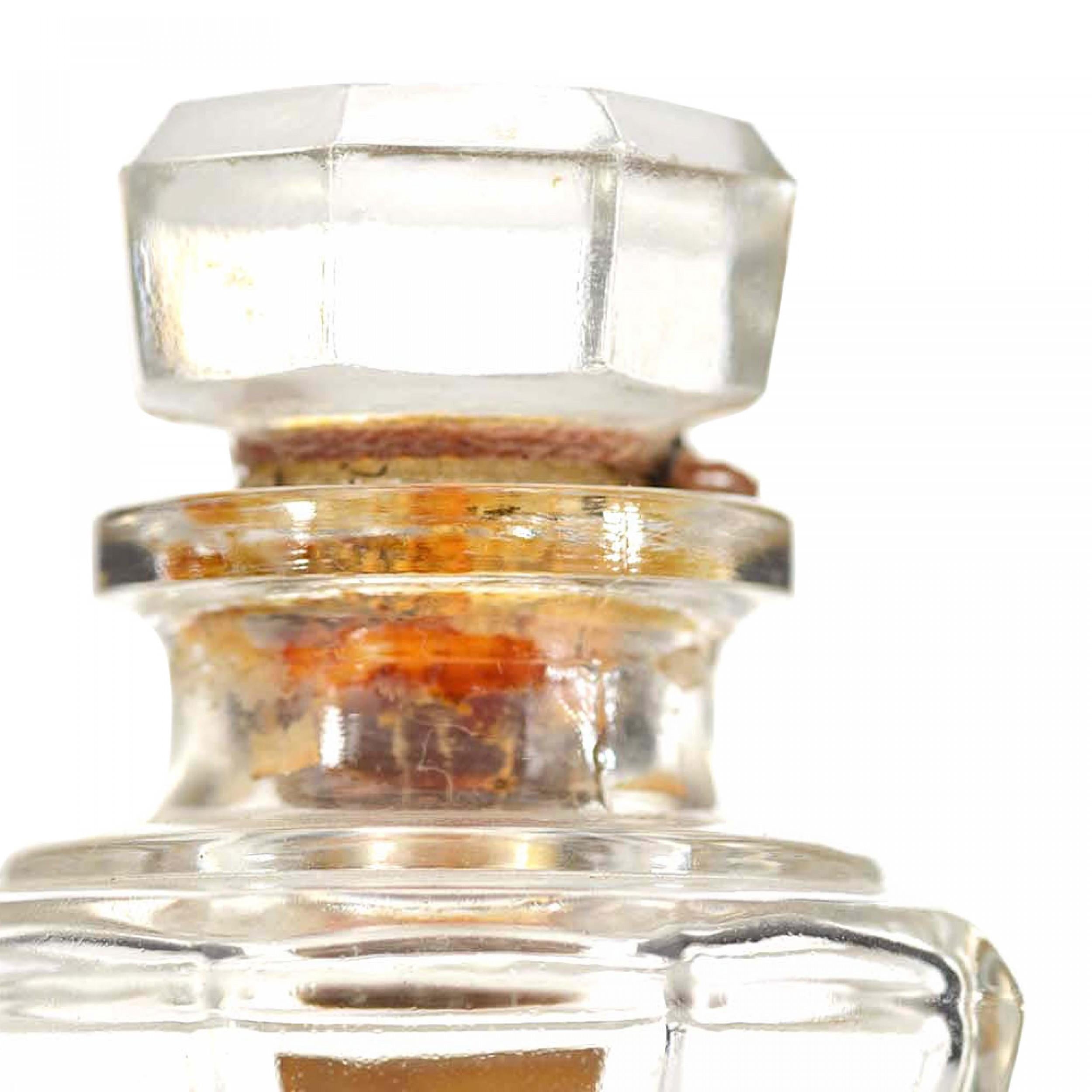 Flacon de parfum octogonal en verre clair de style Art déco français (SINFUL SOUL de GABILLA) avec un design fatigué et un bouchon assorti.