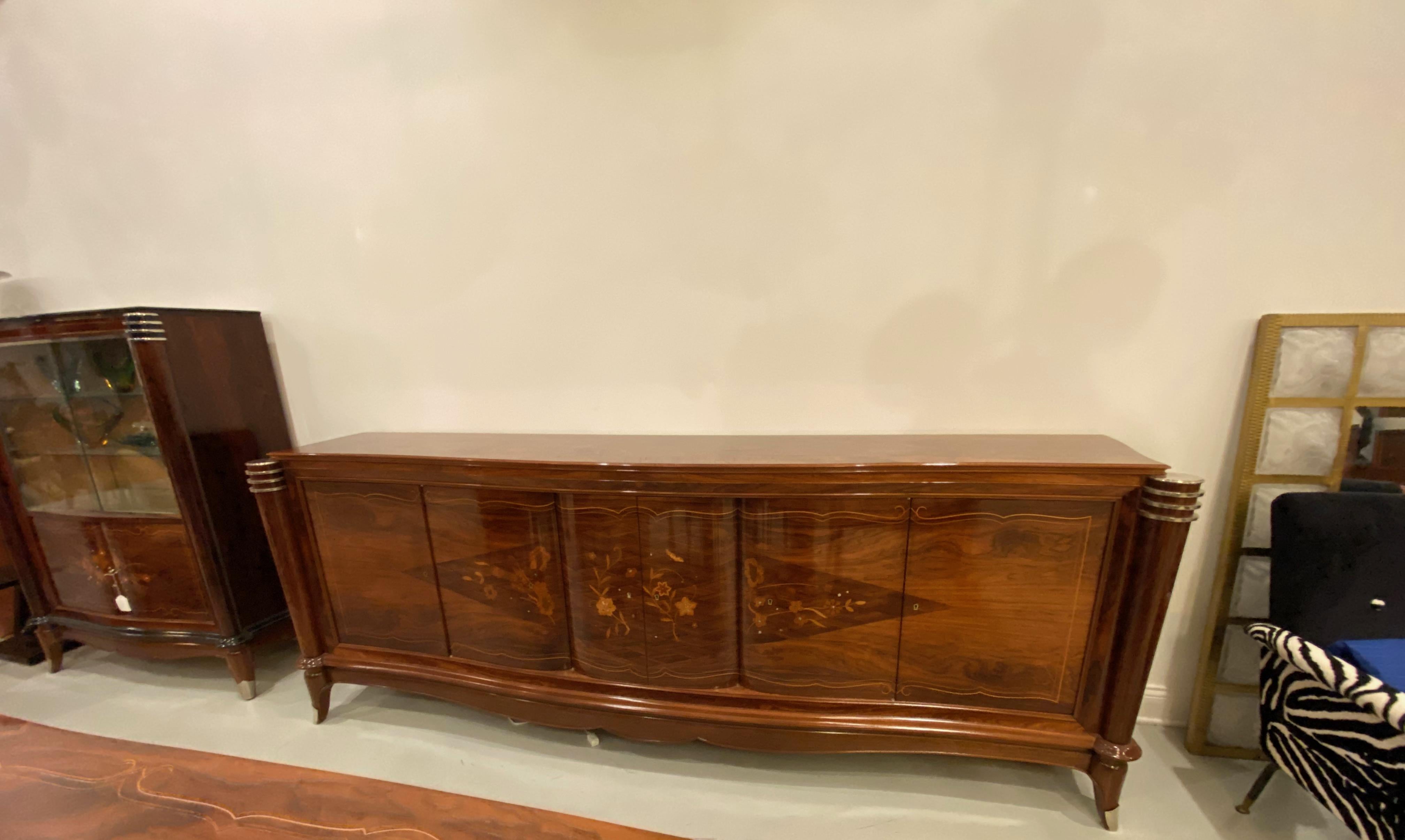 Gorgeous French Art Deco six-door buffet in the style of Jules Leleu. With beautiful rosewood and mother-of-pearl inlay along with stunning marquetry. The middle doors open to reveal a bank of draws while the outer doors reveal shelfs. Having