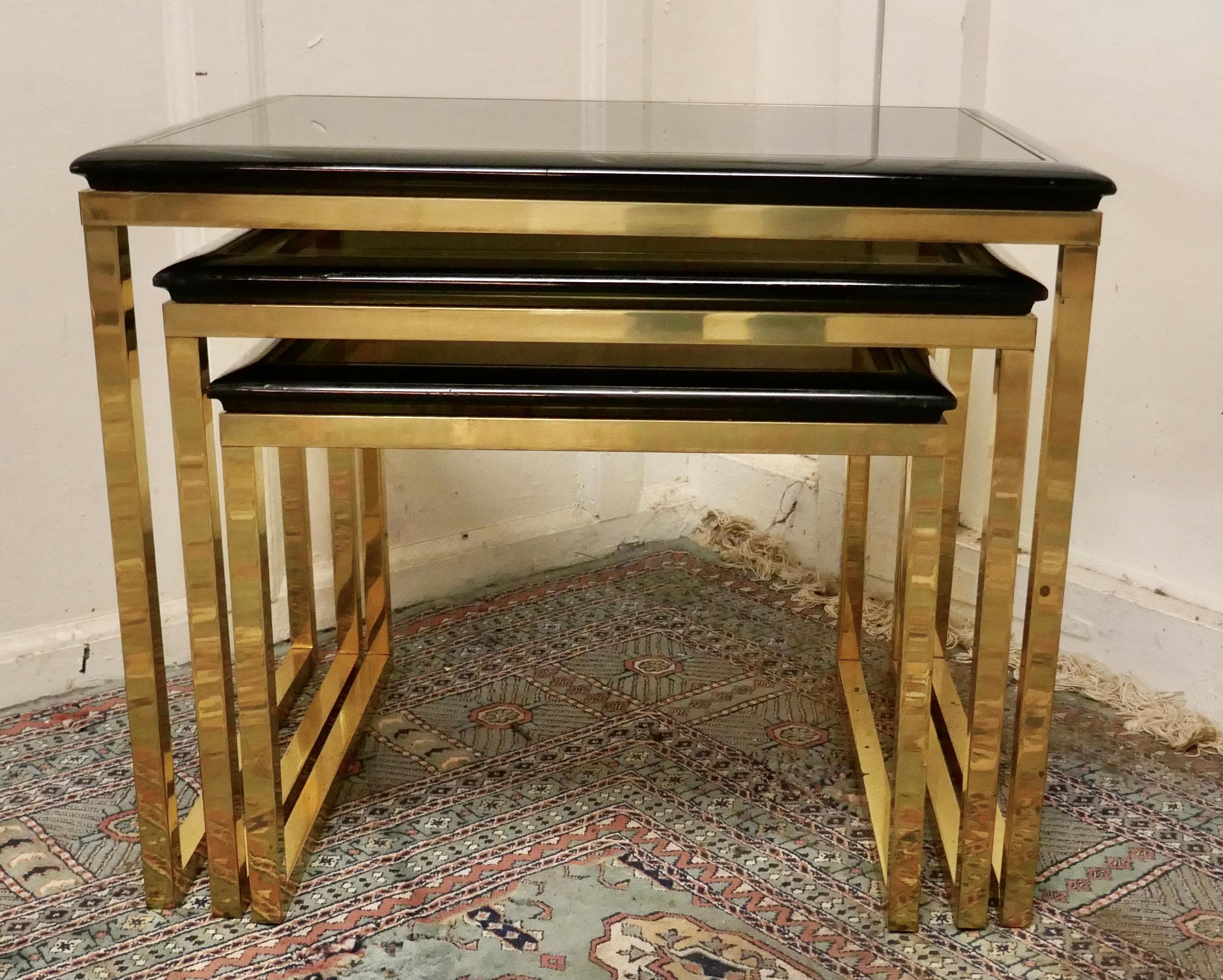 French Art Deco smoked glass & brass nest of tables

This is a very stylish good-looking set of tables, they have smoked glass table tops set on Black and Brass coloured metal frames
The tables are sound and in good condition, as with all Nests