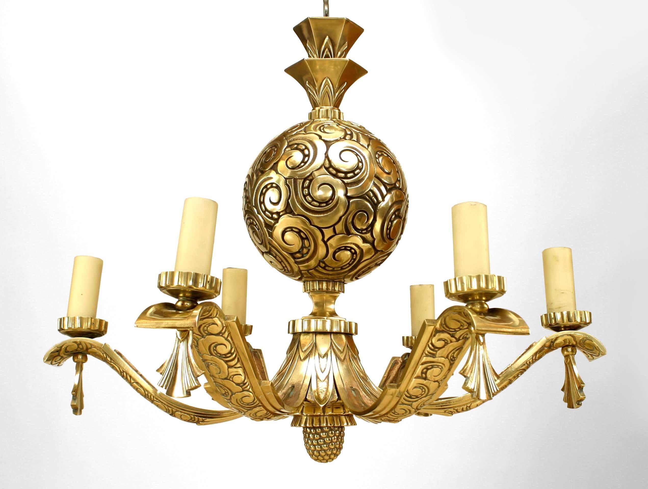 French Art Deco bronze chandelier featuring six scalloped, tassel-ended arms radiating out from a central, scroll-relief design sphere and acorn finial bottom.
