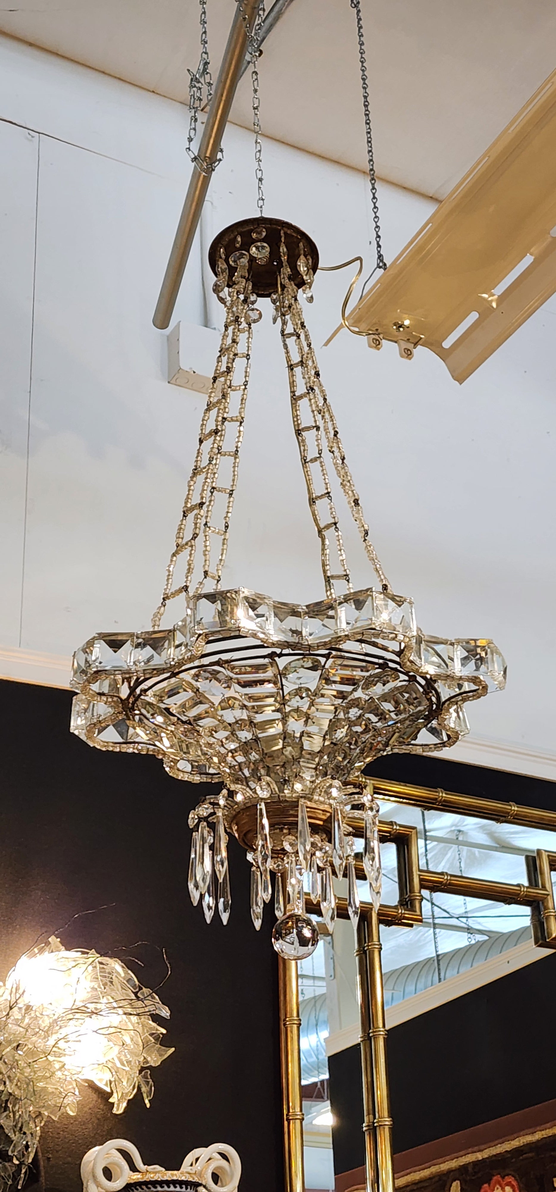 Questo bellissimo lampadario Art Deco è stato realizzato in Francia negli anni '20 a forma di stella a otto punte. Conservando tutti i cristalli e la struttura originale. Può essere illuminato con quattro lampadine da lampadario che si montano