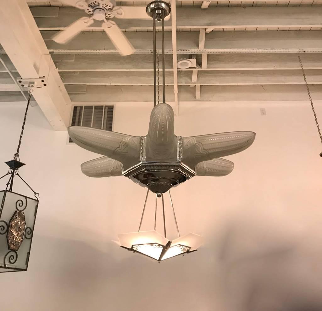 Lampadario a stella Art Deco francese. Ha sei pannelli in vetro trasparente smerigliato modellato con motivi geometrici. Dettagli lucidi su una struttura in bronzo nichelato argentato con un design geometrico. È stato ricablato per l'uso americano