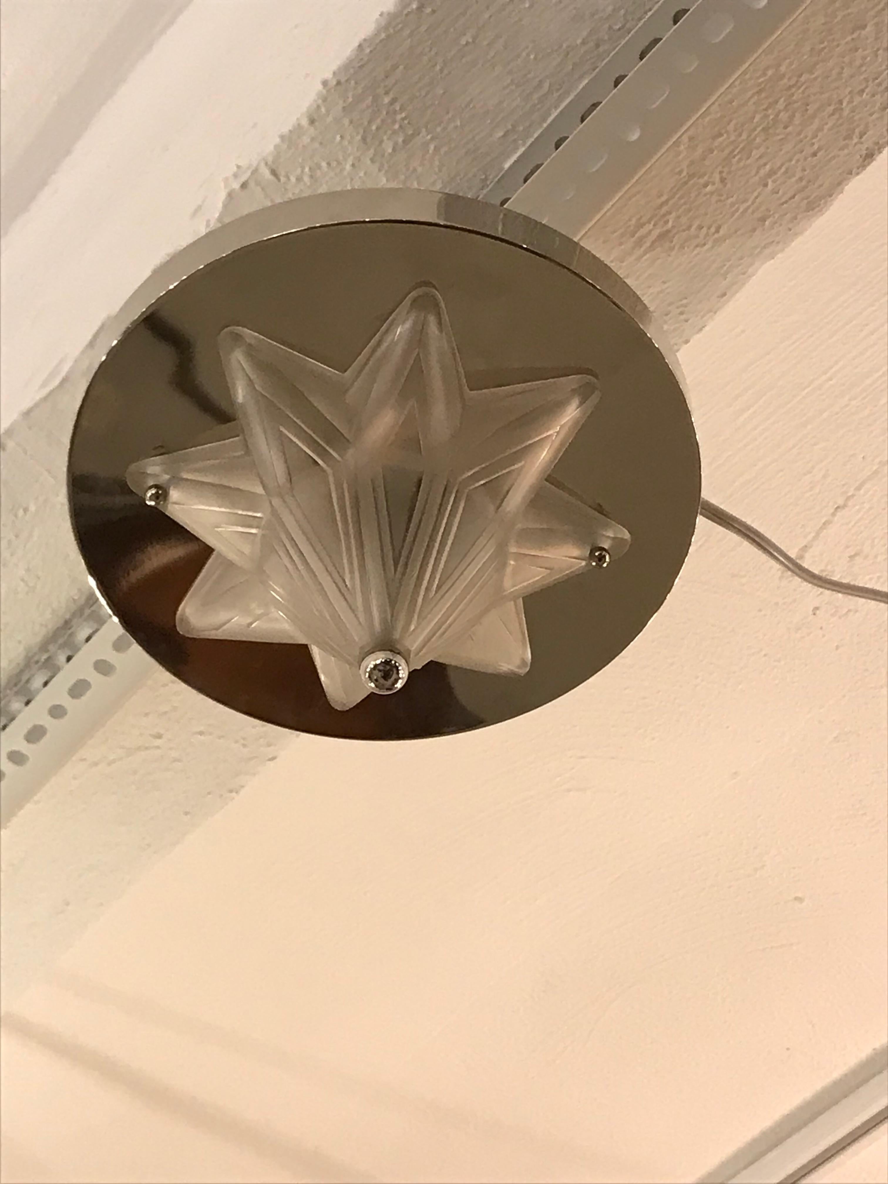 French Art Deco starburst flush mount chandelier signed by Genet et Michon. Clear frosted glass with geometric motif. Mounted on a polished nickeled frame. Has been rewired for American use with two candelabra sockets. Each socket has a max watt of