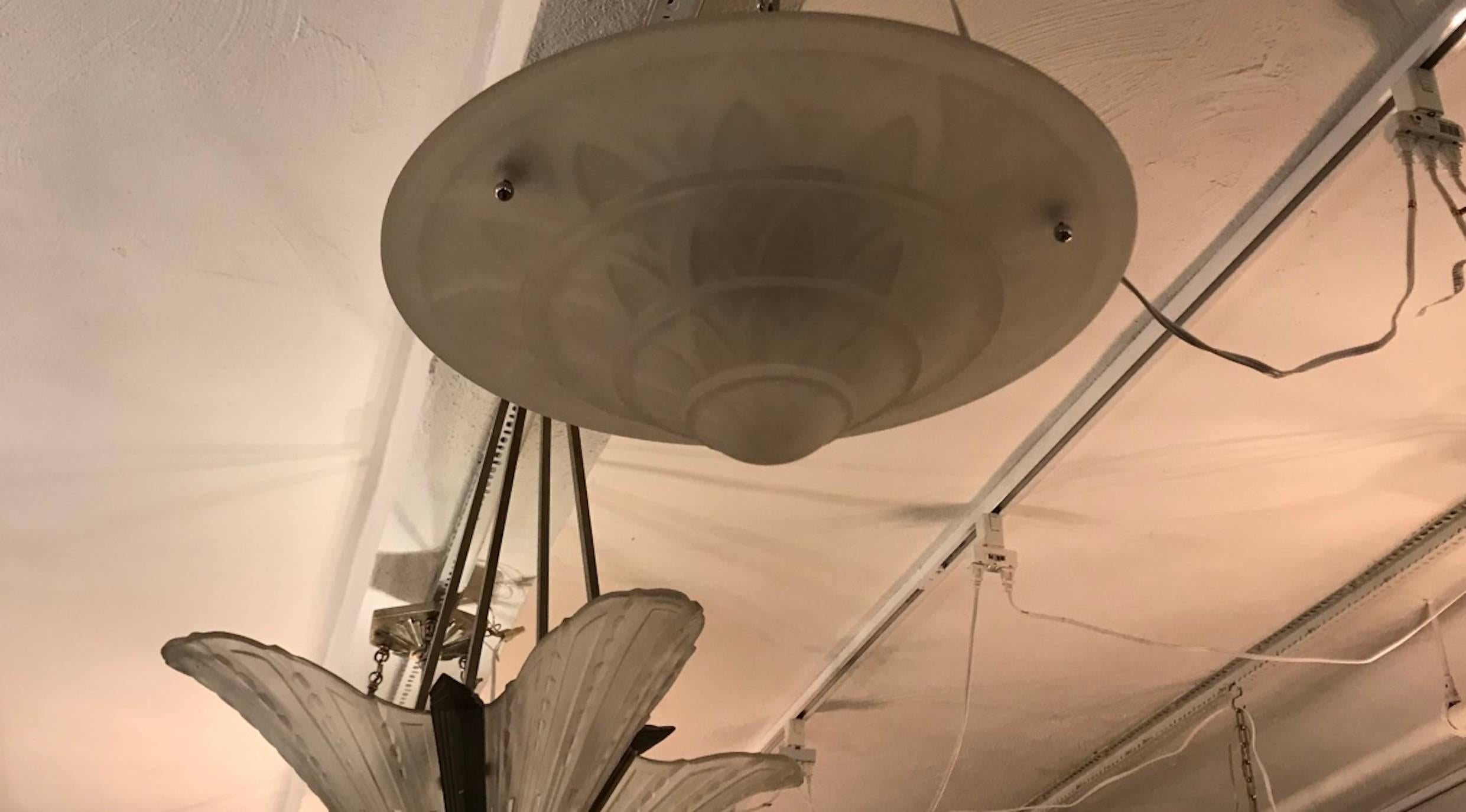 French Art Deco flush mount chandelier. Having frosted glass with over flowing geometric motif details. Supported by three nickel balls. Has been rewired for American use. Taking three candelabra bulbs. In the glass there is a small hair line crack.