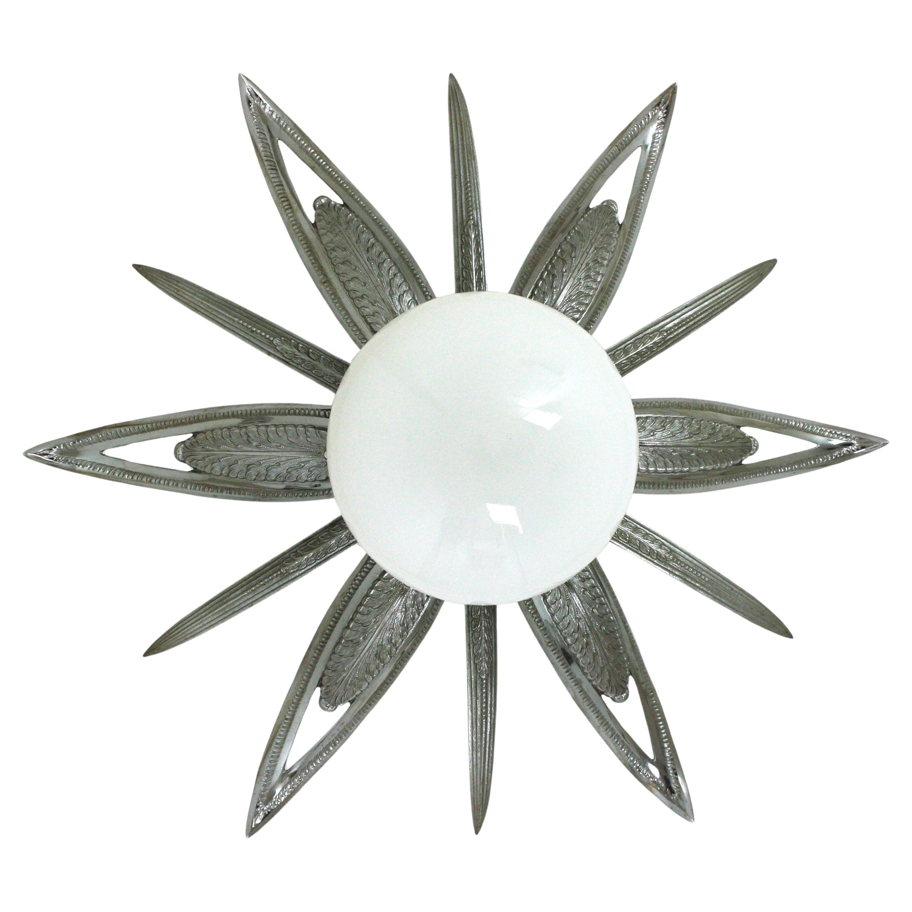 Eye-catching Art Deco starburst shaped engraved and molded silvered bronze ceiling lamp, France, 1930s-1940s.
Large size and 7 lights
This flush mount features a flower burst or starburst with 6 large leaves or rays, 6 pointed smaller rays and an