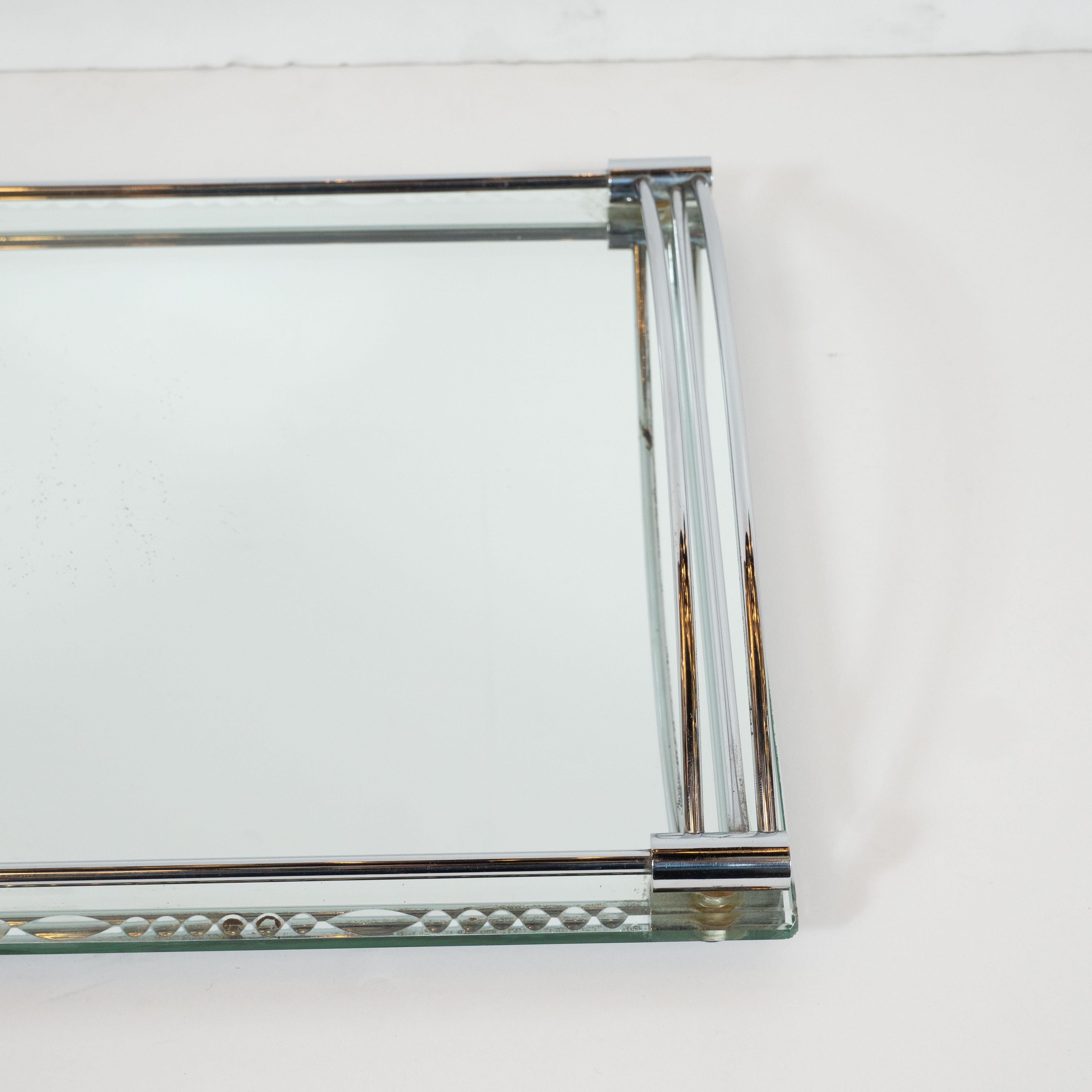 This elegant Art Deco bar tray was realized in France, circa 1930. It offers a mirrored rectangular body with chain beveled detailing running along the perimeter of the longer sides. There are cylindrical details at each corner connected by supports