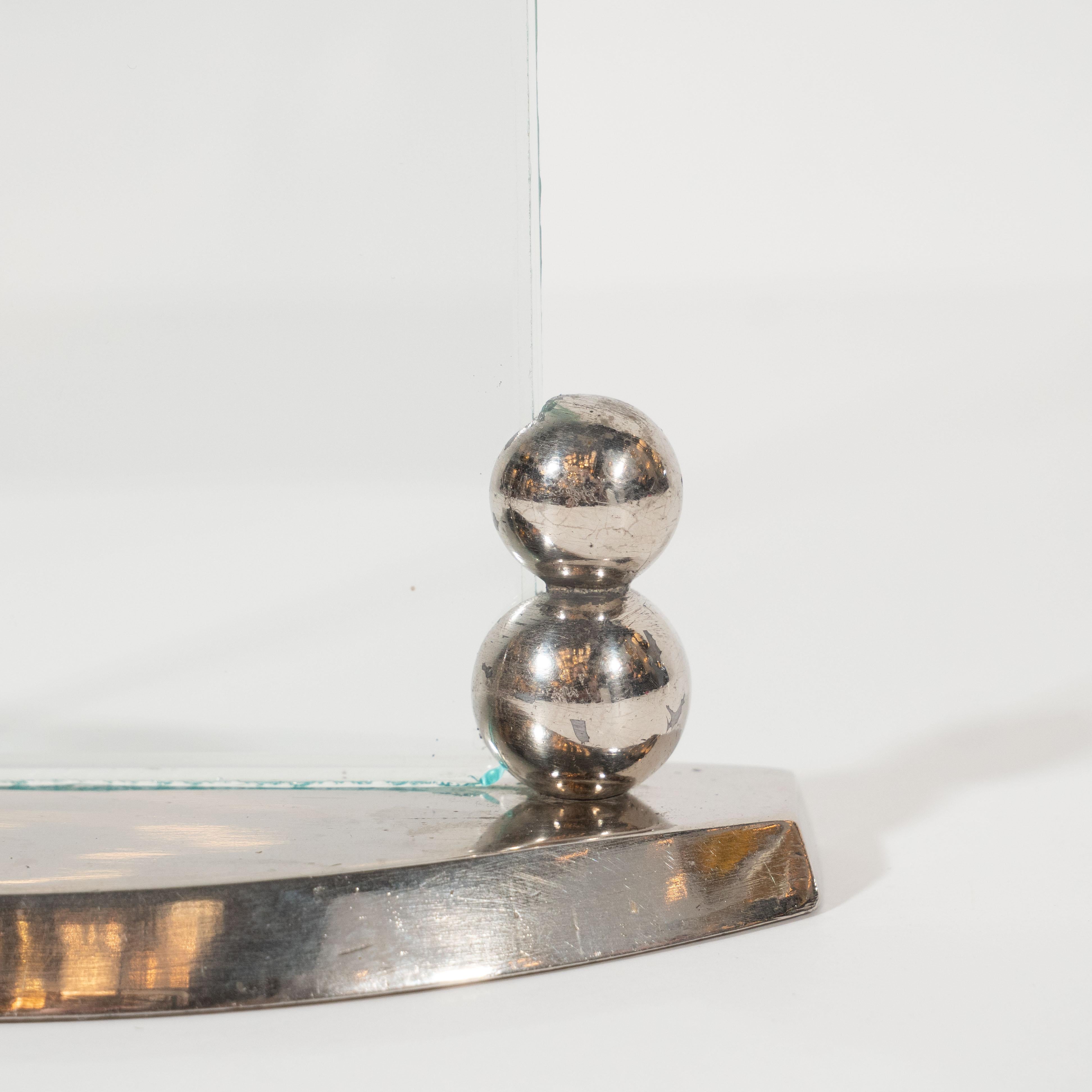 This refined Machine Age picture frame was realized in France, circa 1935. It features a streamlined bow front base from which two pairs of stacked spherical forms of diminishing diameter ascend. Two identical touching rectangular glass panels with