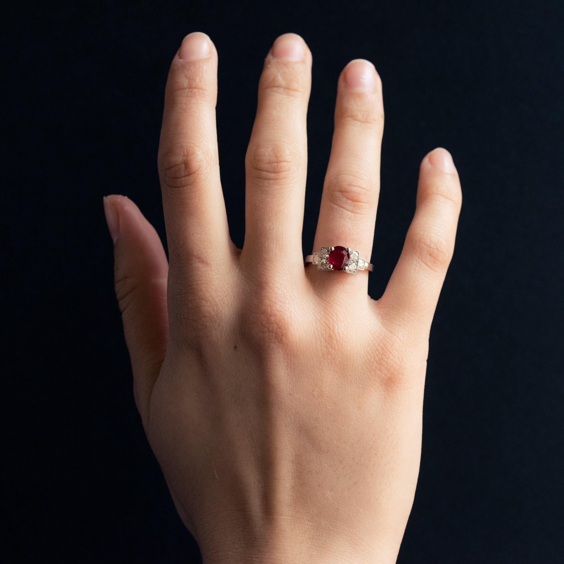 Ring aus Platin, Hundekopfpunze.
Ring im Art-déco-Stil mit einem ovalen Rubin in einer Fassung mit 4 Krallen und 2 x 3 modernen Diamanten im Brillantschliff, die treppenförmig mit Millegrains verziert sind.
Gewicht des Rubins: etwa 1,47