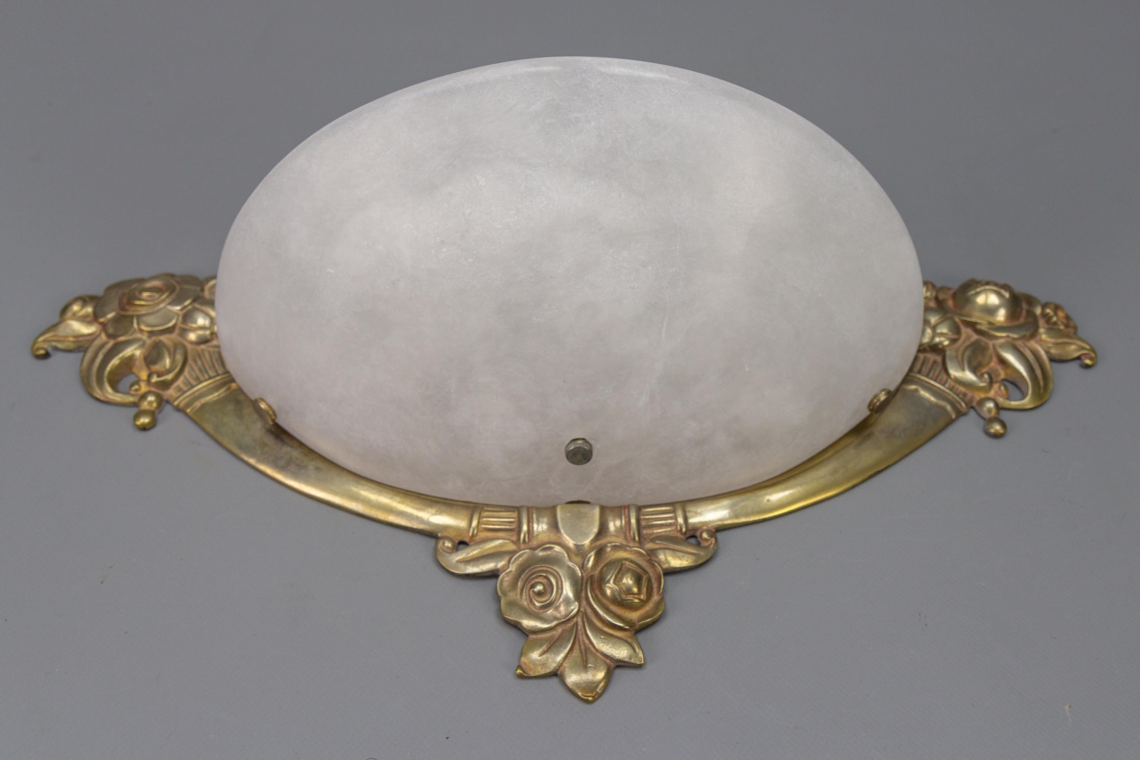 French Art Deco style alabaster and bronze sconce from the 1970s.
This absolutely adorable and ornate sconce features a bronze frame with stylized Art Deco floral motifs and a white alabaster lampshade.
Two new sockets for E14 size light