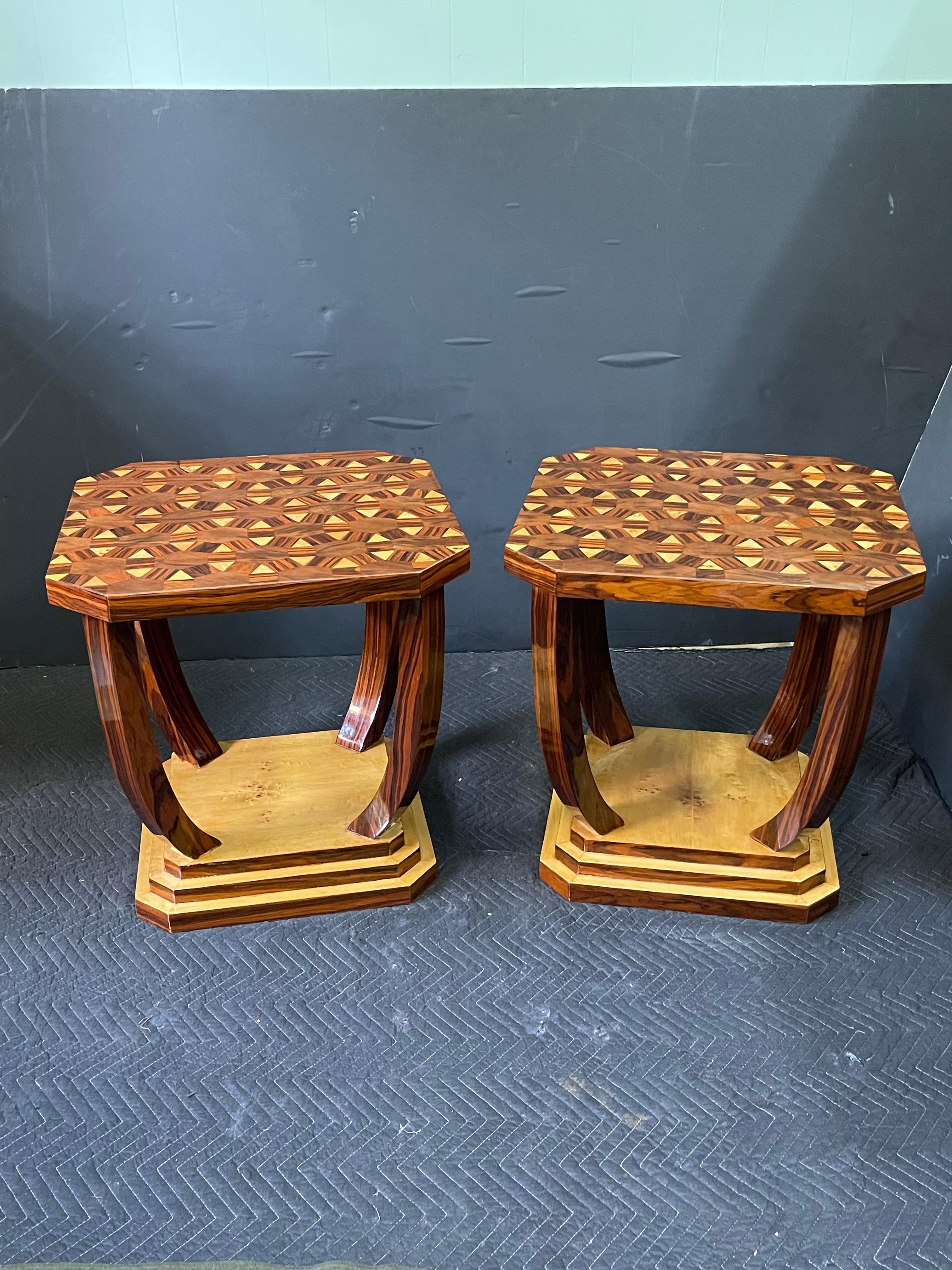 A wonderful pair of 20th century French burl wood side tables in the style of Art Deco. These square side tables are open with canted corners. The thick tops feature geometric marquetry inlays of burled walnut and birds eye maple. They are supported