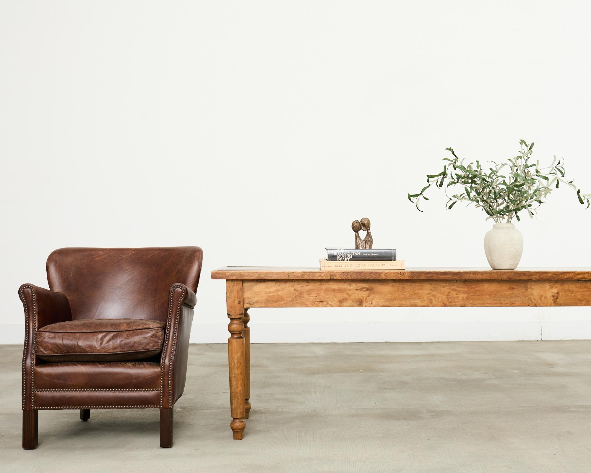 Bellissima poltrona club in pelle in stile art déco francese con un sottile wingback. Questa piccola sedia ha una struttura in legno duro rivestita in pelle di sigaro. La pelle presenta una patina invecchiata e desiderabile, delimitata da chiodi in