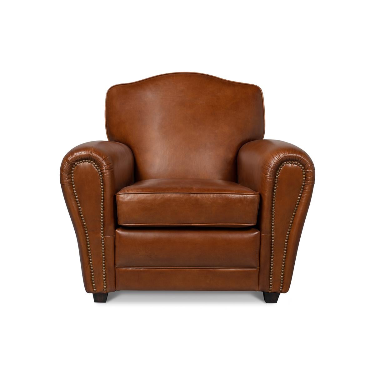 French Art Deco Style club chairs, upholstered with top-grain vintage Havana brown leather with a deep padded upholstered backrest and seat cushion, with boldly rolled arms and raised on square feet.

Dimensions: 36