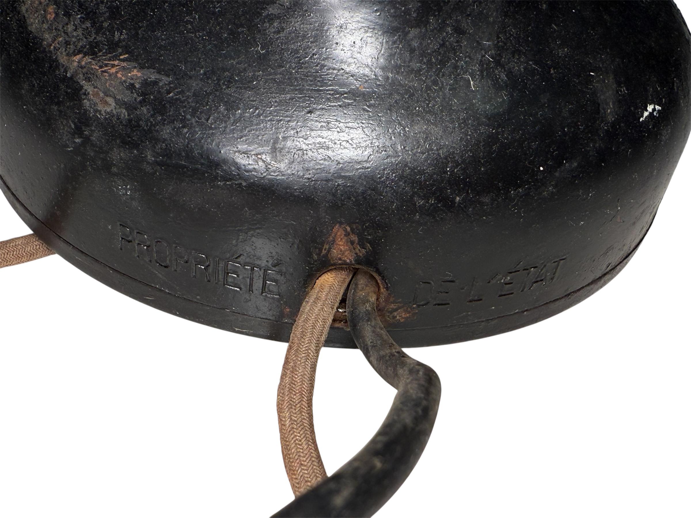 Questo è un telefono da tavolo in stile Art Déco francese. Presenta una base rotonda in metallo di colore nero e una cornetta in bachelite. Una targhetta nella cornetta identifica il produttore del telefono in Francia: Dunyach et Leclert.