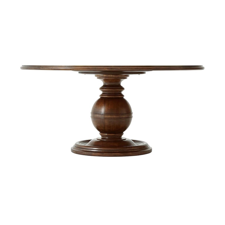 A French Art Deco mahogany and cerejeira dining table, the circular crossbanded and molded edge top above a sphere and collar column with a turned and dished base. Inspired by a 1930s French Art Deco original.
Dimensions: 64