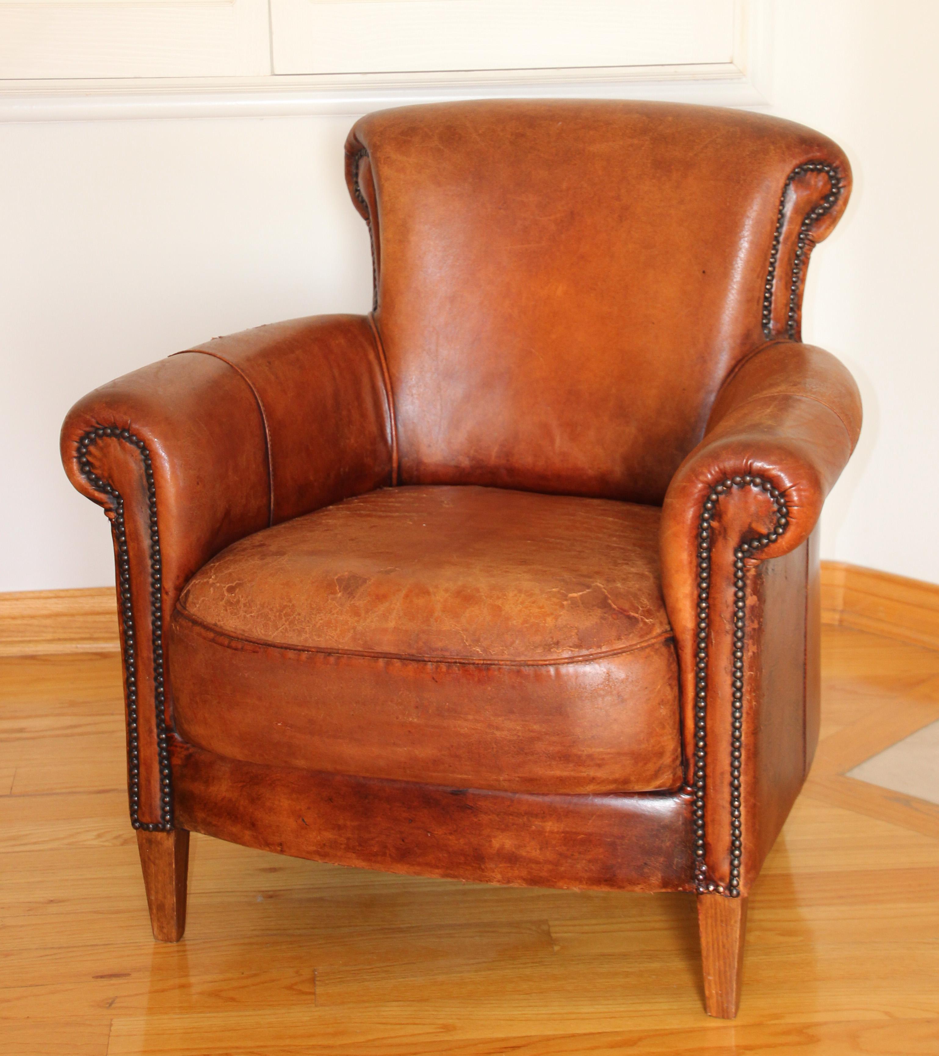 Vintage comfortable French Art Deco brown leather club chair, distressed look, well used.
French deco-style library chair in distressed leather with nailhead detail.
A vintage Art Deco armchair upholstered in brown caramel-colored leather with