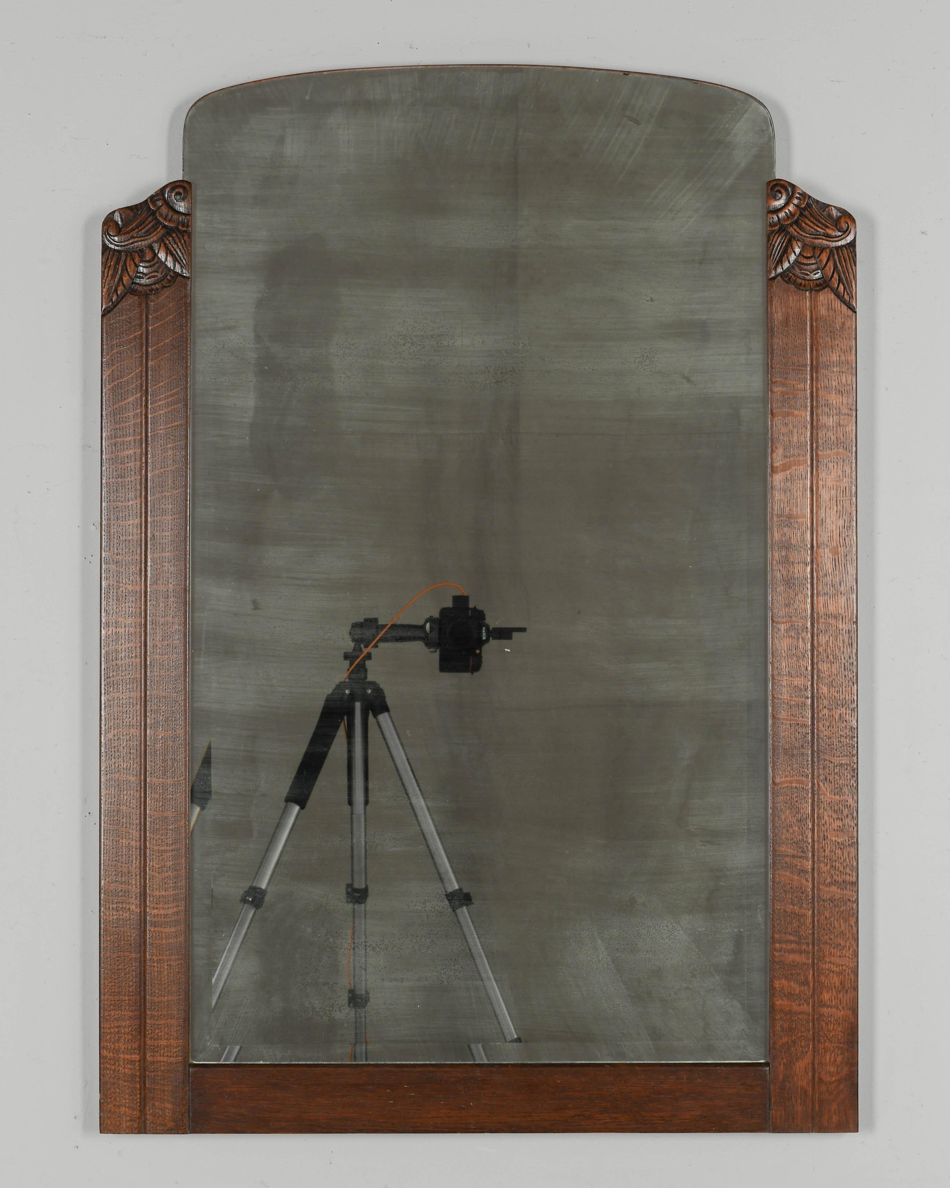 A French Art Deco style oak framed mirror with carved details. Original beveled mirror with nice fogged patina. Circa 1950s
Dimensions: 30.25