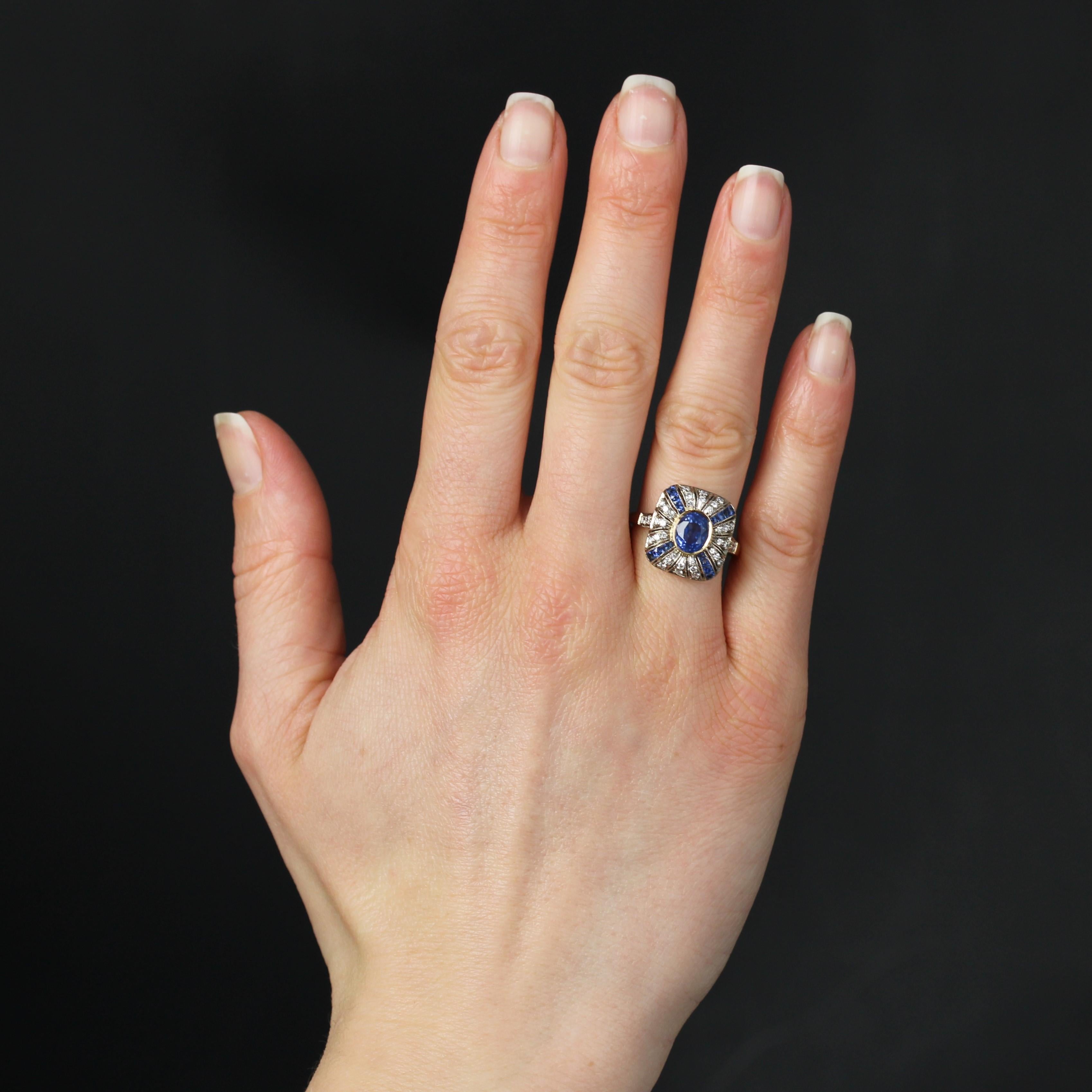 Ring in 18 karat yellow and white gold, eagle head hallmark.
An elegant Art Deco-style ring with a cushion-shaped setting featuring a sapphire in the center. The entire cushion is adorned with alternating lines of falling calibrated sapphires and