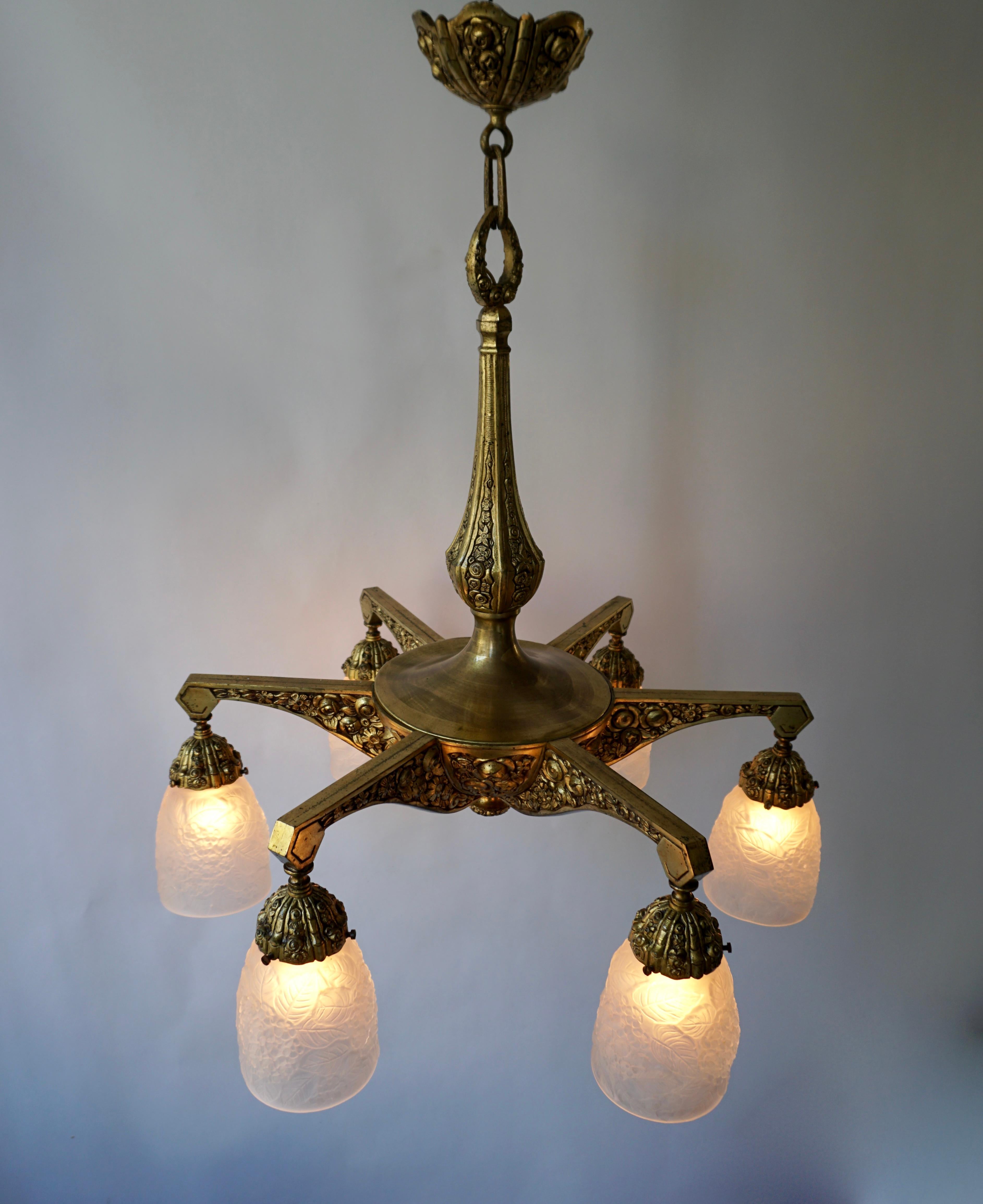 French Art Deco style bronze chandelier with floral motifs from the 1930s. Six bronze arms, each with frosted glass shade and a socket for E 27 light bulb.
Measures: Diameter 60 cm.
Height fixture 60 cm.
Total height including the chain and