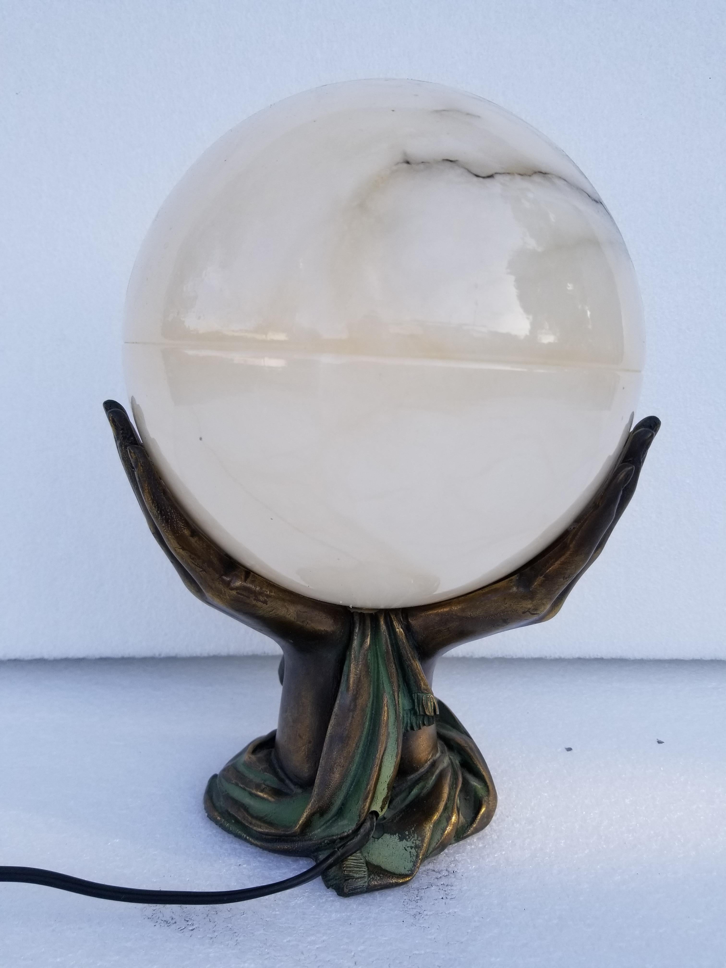 Superb Art Deco style French table lamp figuring 2 hands holding a marble globe.
1 light, 40 watts Bulb Max.