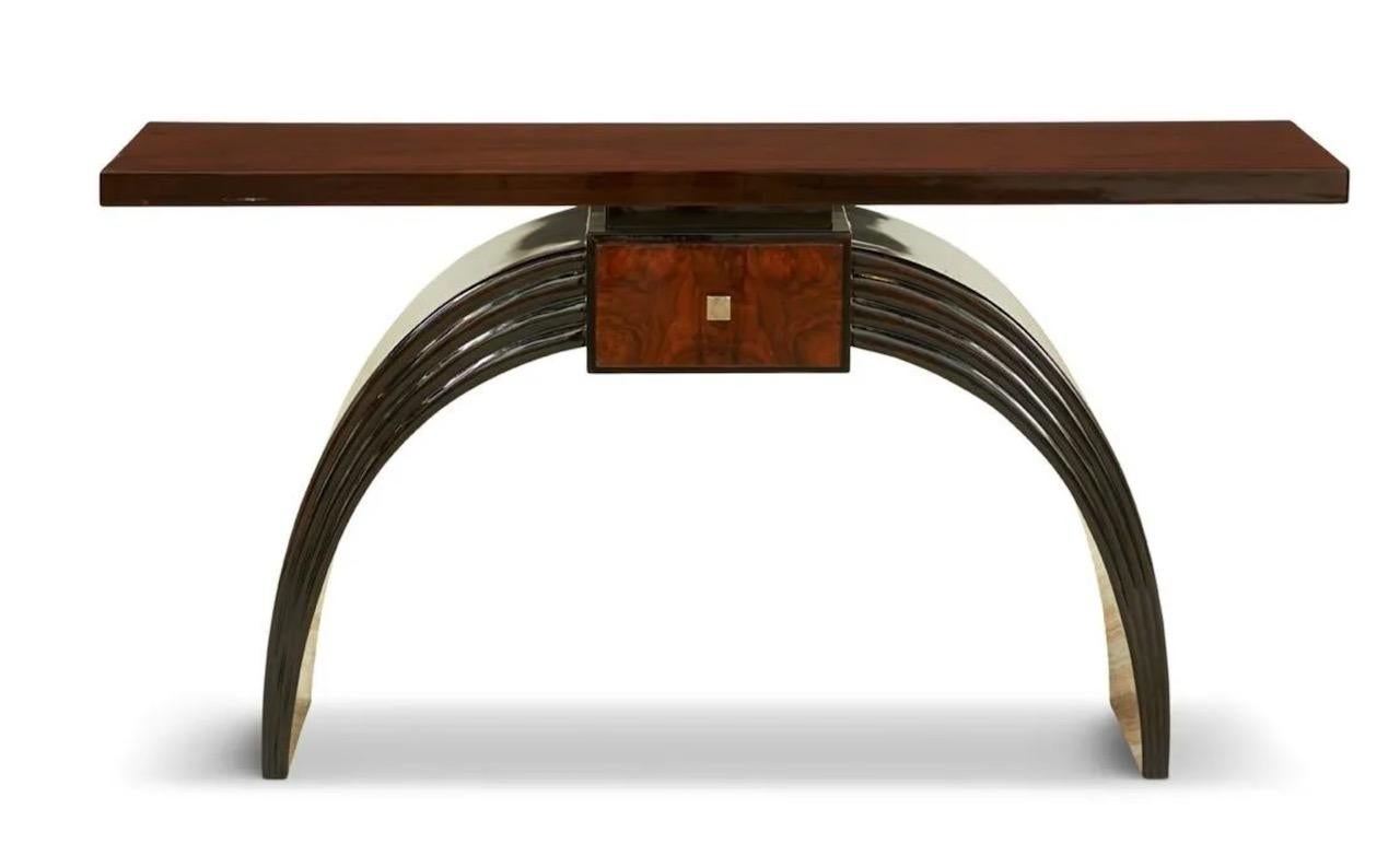 This French Art Deco-Style Walnut-Veneered and Ebonized Console has beautiful lines and simple elegant detailing. The walnut top is supported by an ebonized arch base with a boldly reeded front and fitted with a single burled walnut drawer. The