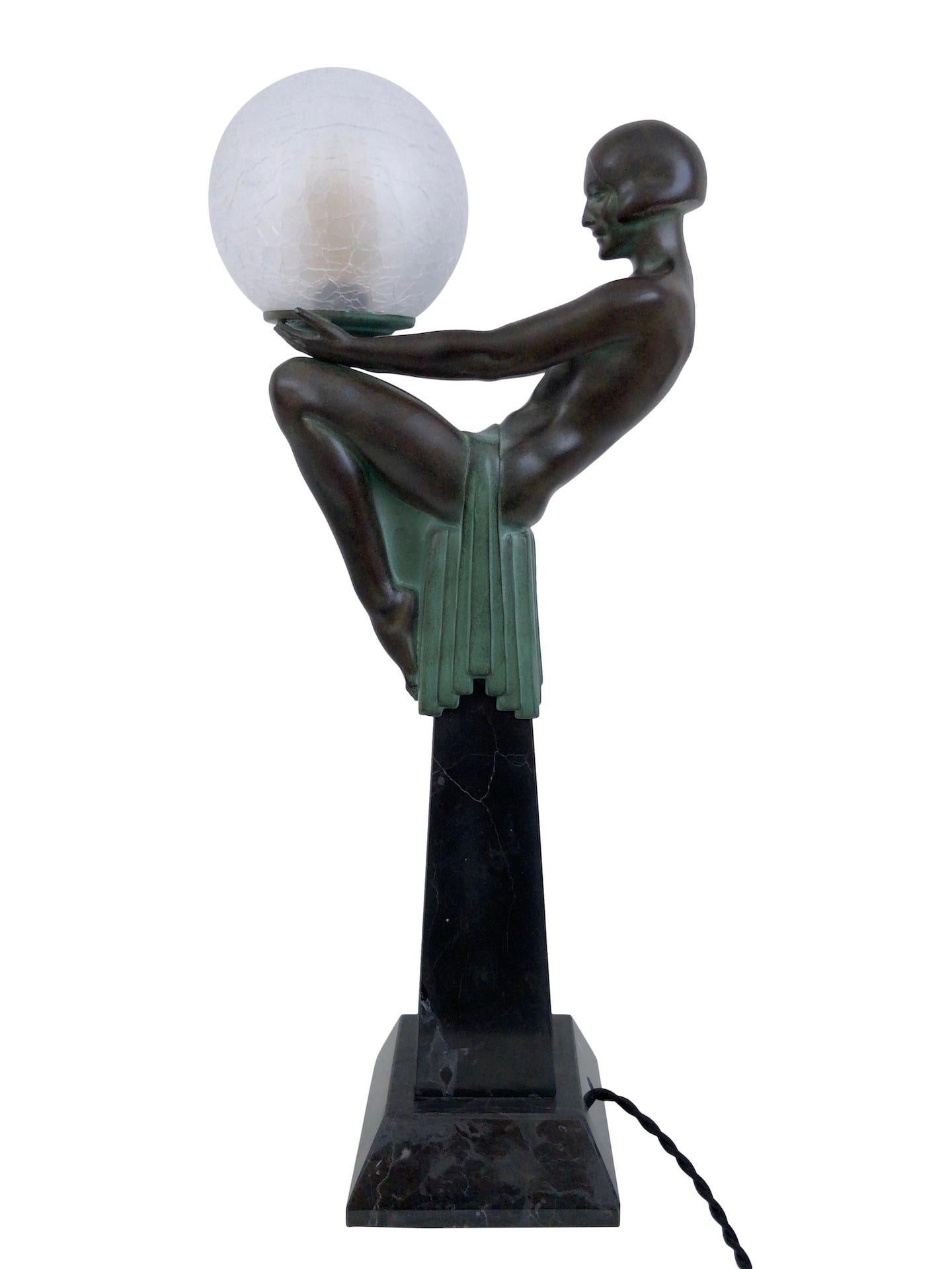 “Enigme” 
Original “Max Le Verrier”
Art Deco style, France 

Beautiful sitting lady holding a lighted glass ball 
Table lamp, sculpture made in “Régule” (spelter) 
Socle in black marble (could have a different marbleization than the picture)
