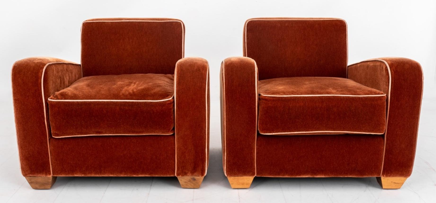 
French Art Deco style club chairs in the manner of Jules Leleu (French, 1883-1961) for Maison Leleu, with square backs and angled arm panels flanking a square seat, upholstered allover in russet wool velvet with contrasting camel welt, on tapering
