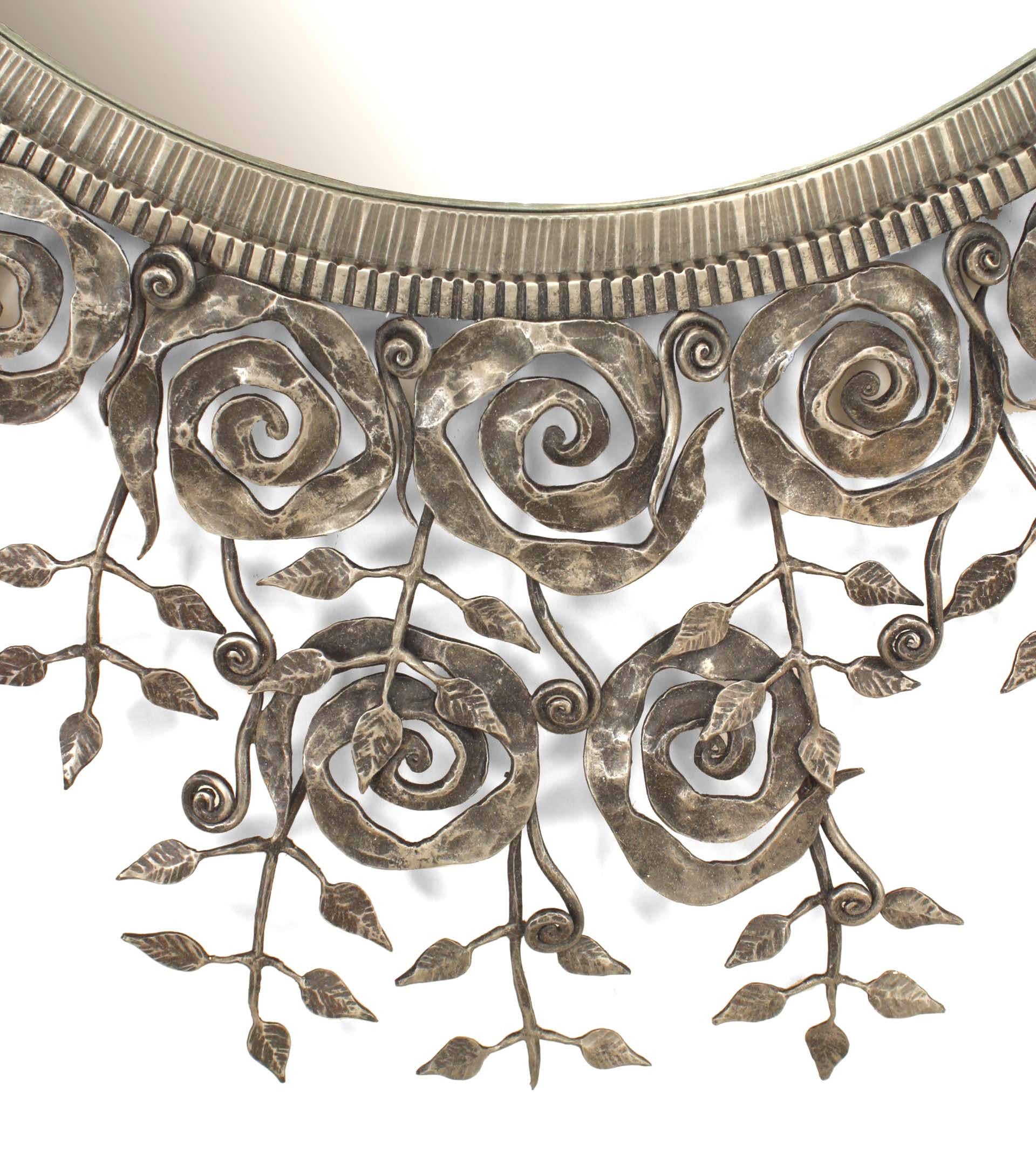 French Art Deco-style wrought iron wall mirror with a filigree floral and scroll border on two sides of a centered round mirror.
