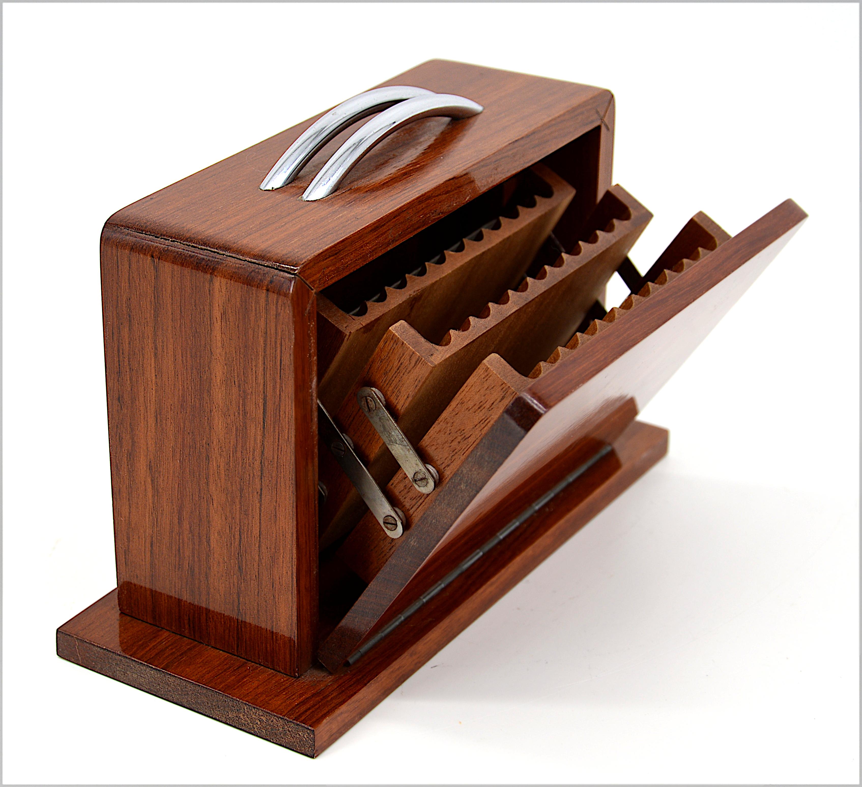 Cigarrera francesa Art Decó, Francia, años 20. Maleta. Madera y metal cromado. Medidas: Para 33 cigarrillos de hasta 7,2 cm cada uno. Medidas: Alto 13 cm, ancho 19 cm, fondo 8 cm. Sólo algunas pequeñas huellas de la edad.