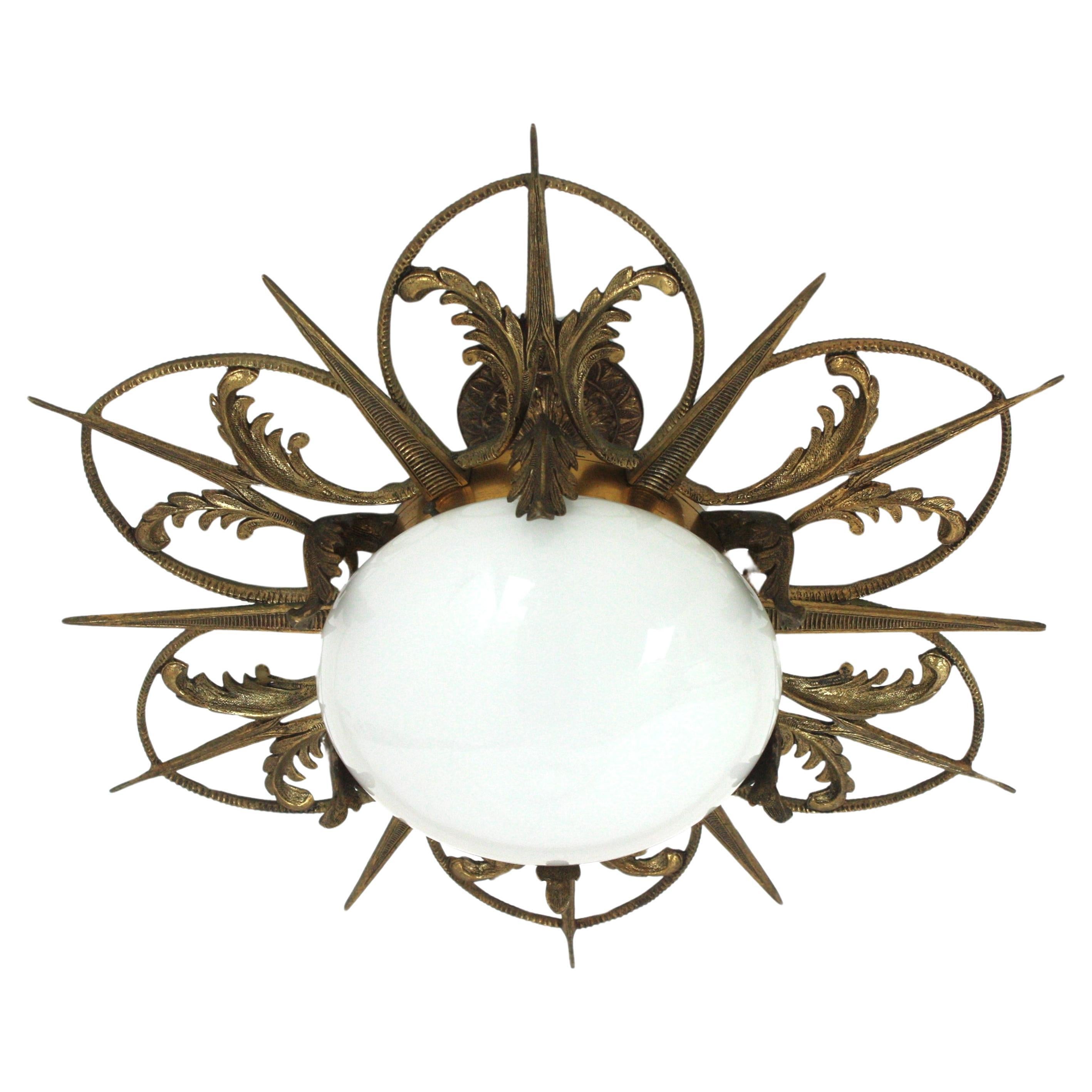 Exquisite Art Deco flower or sunburst ceiling lamp, Engraved and Molded bronze, Milk Glass. France, 1930s.
This flush mount features a flower burst or sunburst with alternating rays and petals and foliage motifs thorough. At the central part an