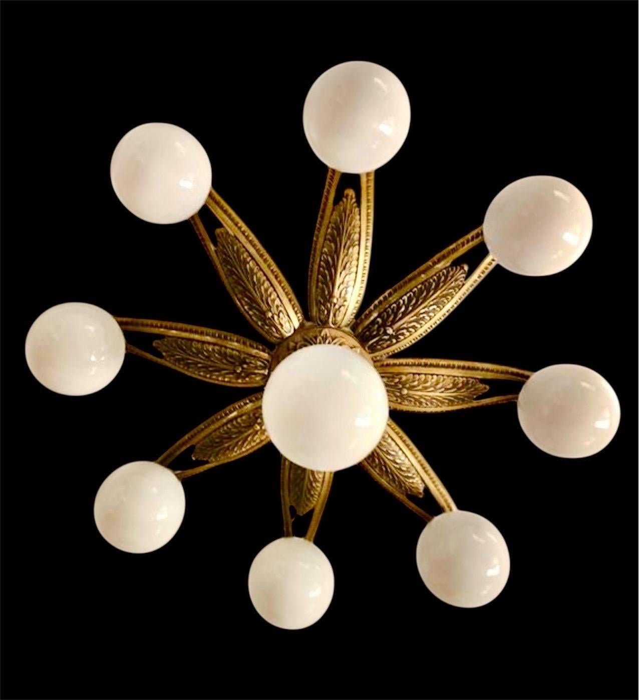 Plafonnier Art Déco en forme de fleur ou de soleil, en bronze gravé et moulé, avec verre de lait opalin. France, années 1930. Ce plafonnier présente un motif stylisé de fleur ou de soleil. Au centre se trouve un magnifique globe en verre opale qui