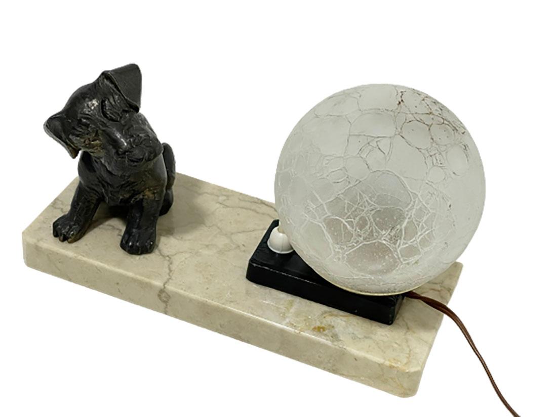 Französische Art-déco-Tischlampe, 1930er-Jahre

Französische Art-Déco-Lampe mit Hundefigur aus Bronze auf einem Marmorsockel, hergestellt in Frankreich in den 1930er Jahren. Die Glaskugellampe im Craquelé-Stil hat Gebrauchsspuren und steht auf einem