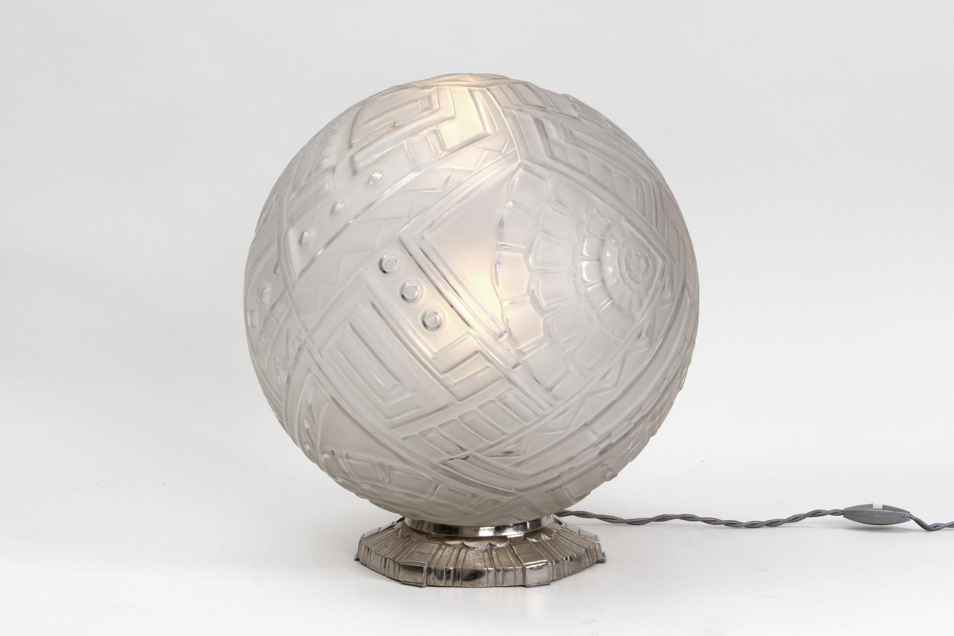 Grand et très rare modèle de lampe de table Art Déco par la manufacture parisienne de verre Sabino. Boule ronde en grand format avec un décor géométrique typique de Formations et une base en bronze nickelé. Circa 1930.