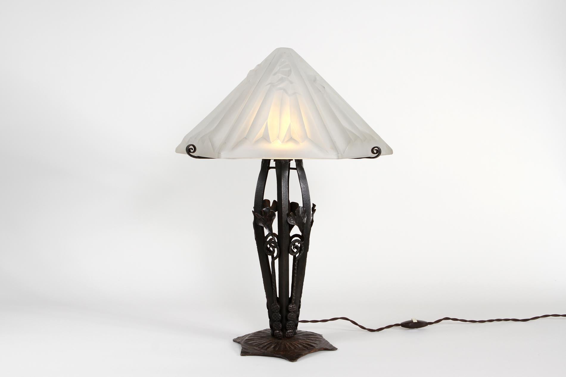 Original französische Art Deco Tischlampe von Degué, Sockel aus Schmiedeeisen und Lampenschirm von Degué, signiert. Die Originalität der Leuchte liegt in der Form des Lampenschirms mit dem ikonischen Degué-Dekor. Bigli macht ein schönes Licht und