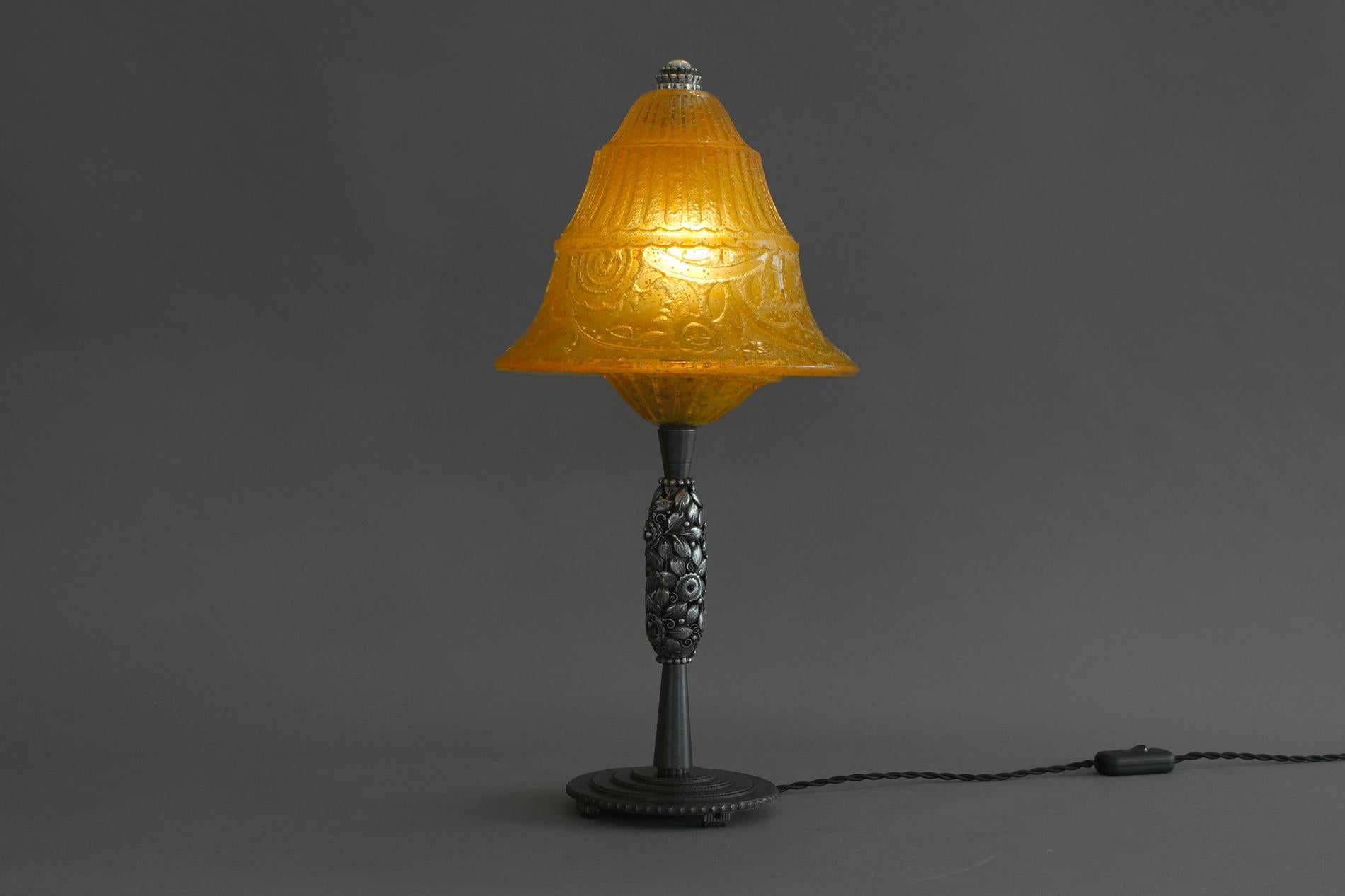 Exceptional and really rare french art deco table lamp in wrought iron by Edgar Brandt, signed on the base. The glass is by Daum and the particularity is to be incrusted with tiny gold glitter. 


  