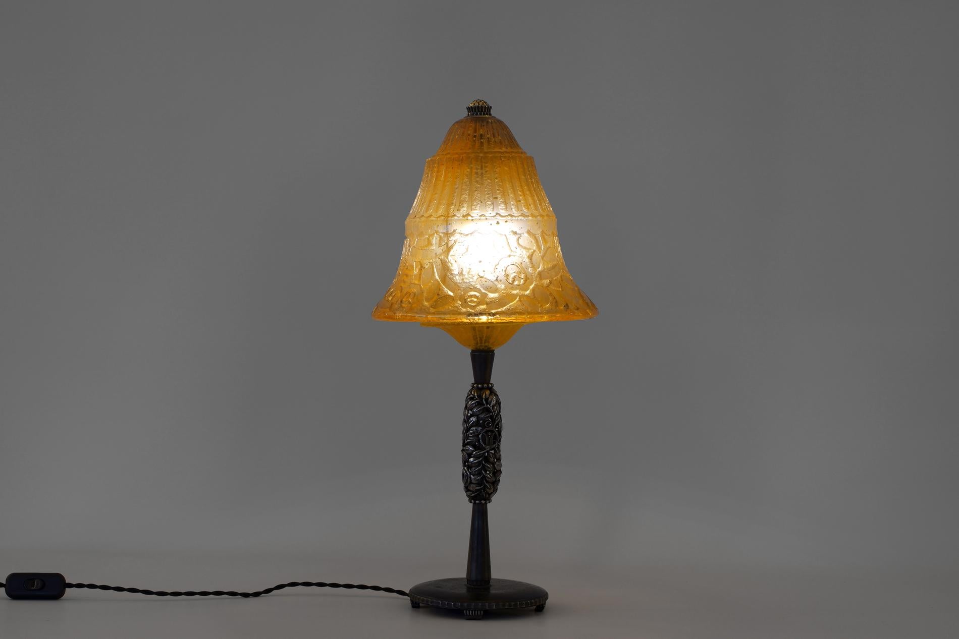 Exceptional and really rare french art deco table lamp in wrought iron by Edgar Brandt, signed on the base. The glass was made by Daum and the particularity is to be incrusted with tiny gold glitter.

For information, we have two of them with a