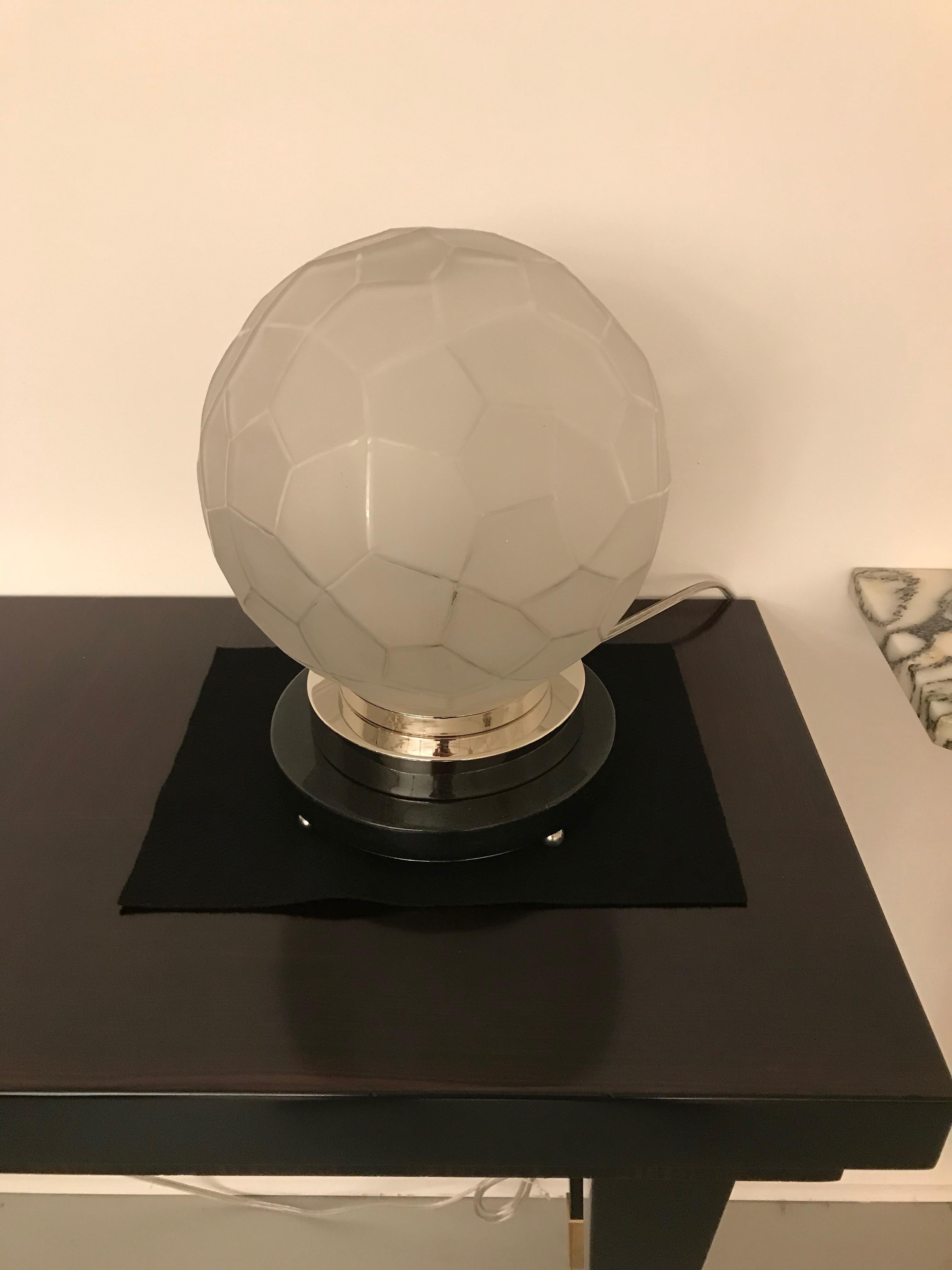 Lampe de table Art déco française créée par Genet et Michon. L'abat-jour est en verre clair dépoli avec des détails polis à motif géométrique. Maintenue par une base en bronze argenté reposant sur un socle en marbre. Le câblage a été refait pour une