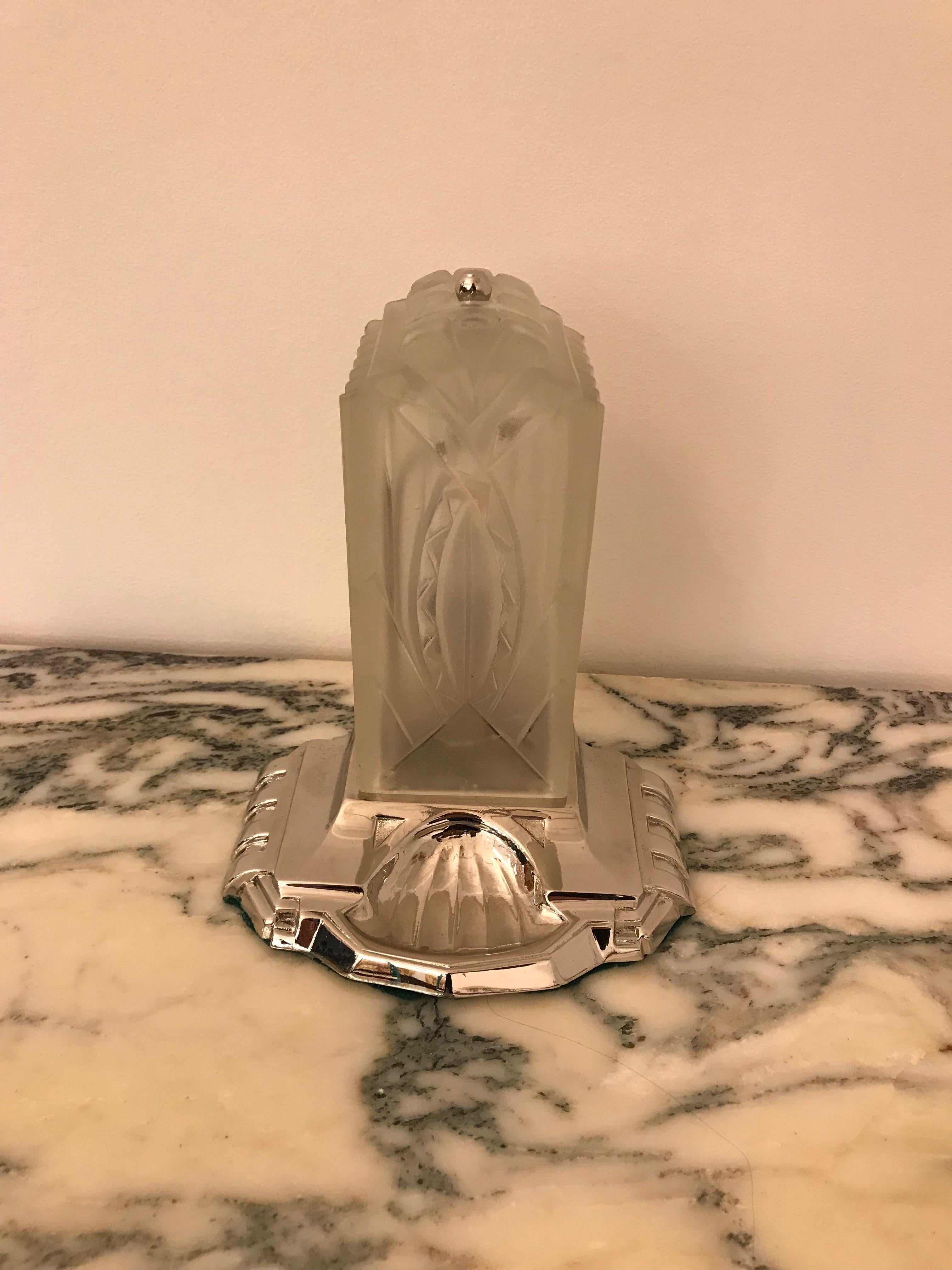 Beautiful French Art Deco table lamp signed by Hugue. Clear frosted glass shade with geometric motif signed Hugue. Having a polished nickel bronze base. The glass shade measures 6.5 inches in height. Has been rewired for American use with one