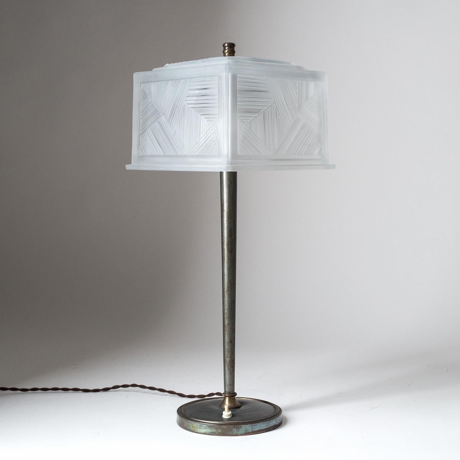 Very rare tall table lamp by Sabino, Paris, circa 1930. Slender, dark patinated, hardware with a heavily textured glass shade. Very thick glass with geometric pattern and a satin finish. Very good original condition with two brass and ceramic E27