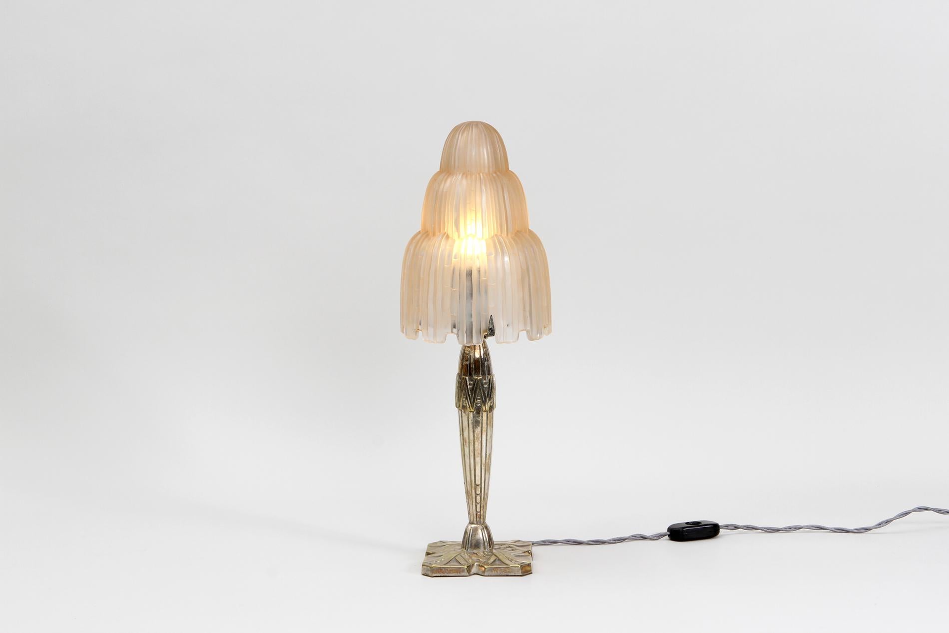 Lampada da tavolo Art Deco francese originale di Sabino con paralume a cascata e base nella sua patina originale di bronzo dorato. Circa 1930.

La lampada è presente anche nella documentazione: Art et Industrie 1926, pag. 38. 