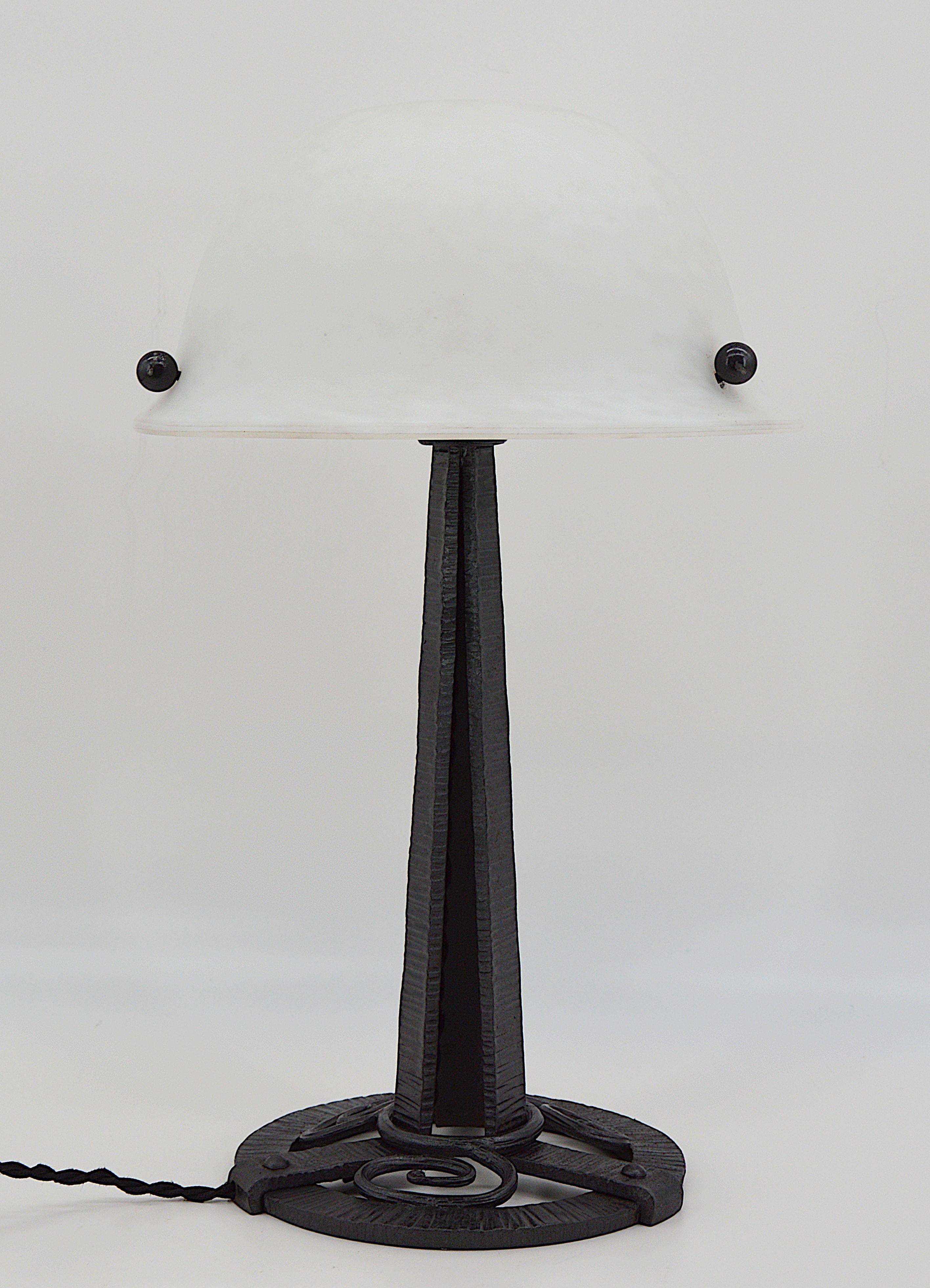French Art Deco table lamp, France, circa 1925. Glass and wrought iron. Very nice lampshade in white mottled glass. Double glass, white enamels are applied between the two layers. On its wrought iron base. Same period as Daum, Schneider, Muller