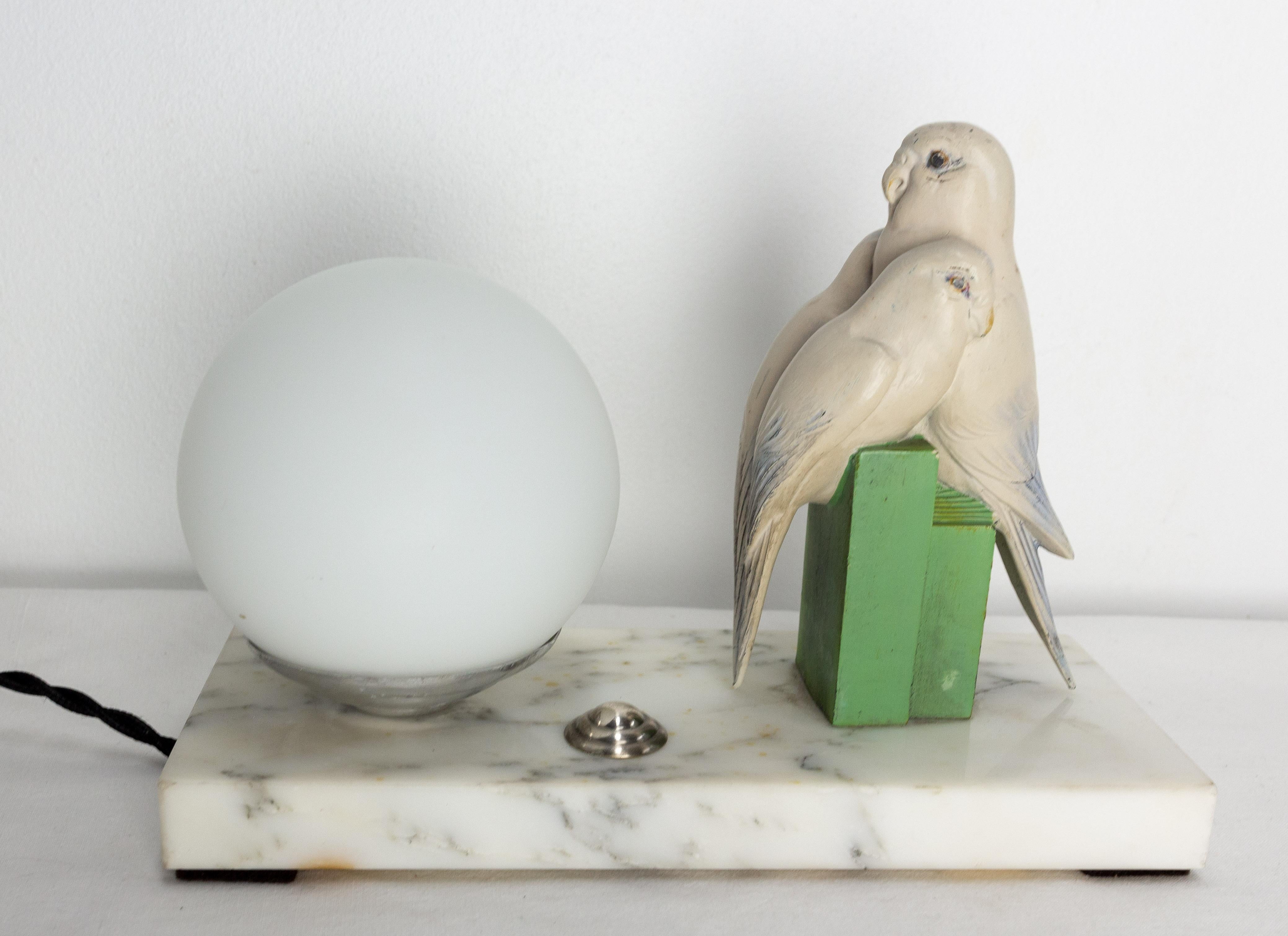 Art Déco table lamp decorated with a parakeets trio. An adult and two young o
Chrome, glass globe, marble and painted spelter.
French circa 1930.
This can be rewired to USA or EU and UK standards.
Good condition with marks of age on the