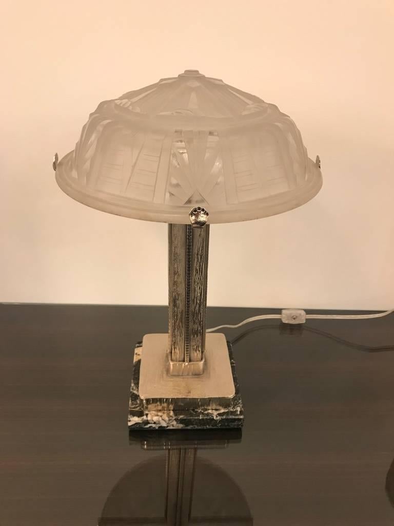 French Art Deco table lamp signed by Muller Freres Luneville. Having beautiful geometric shade in frosted glass with polished details. Held by a polished nickel base sitting on marble. Has been rewired for American use having one candelabra socket.