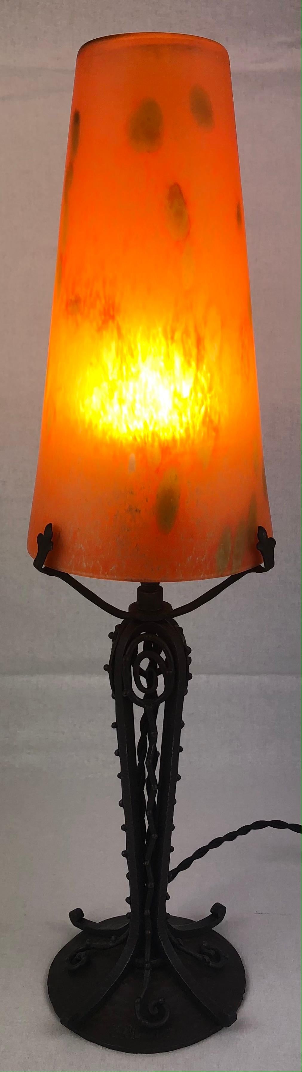 A fine art deco wrought iron lamp designed by Louis Trichard featuring a beautiful pate de verre shade in the style of Muller Freres. The base is made in the style and quality of Edgar Brandt. 

This exquisite table or desk lamp comes from the Louis