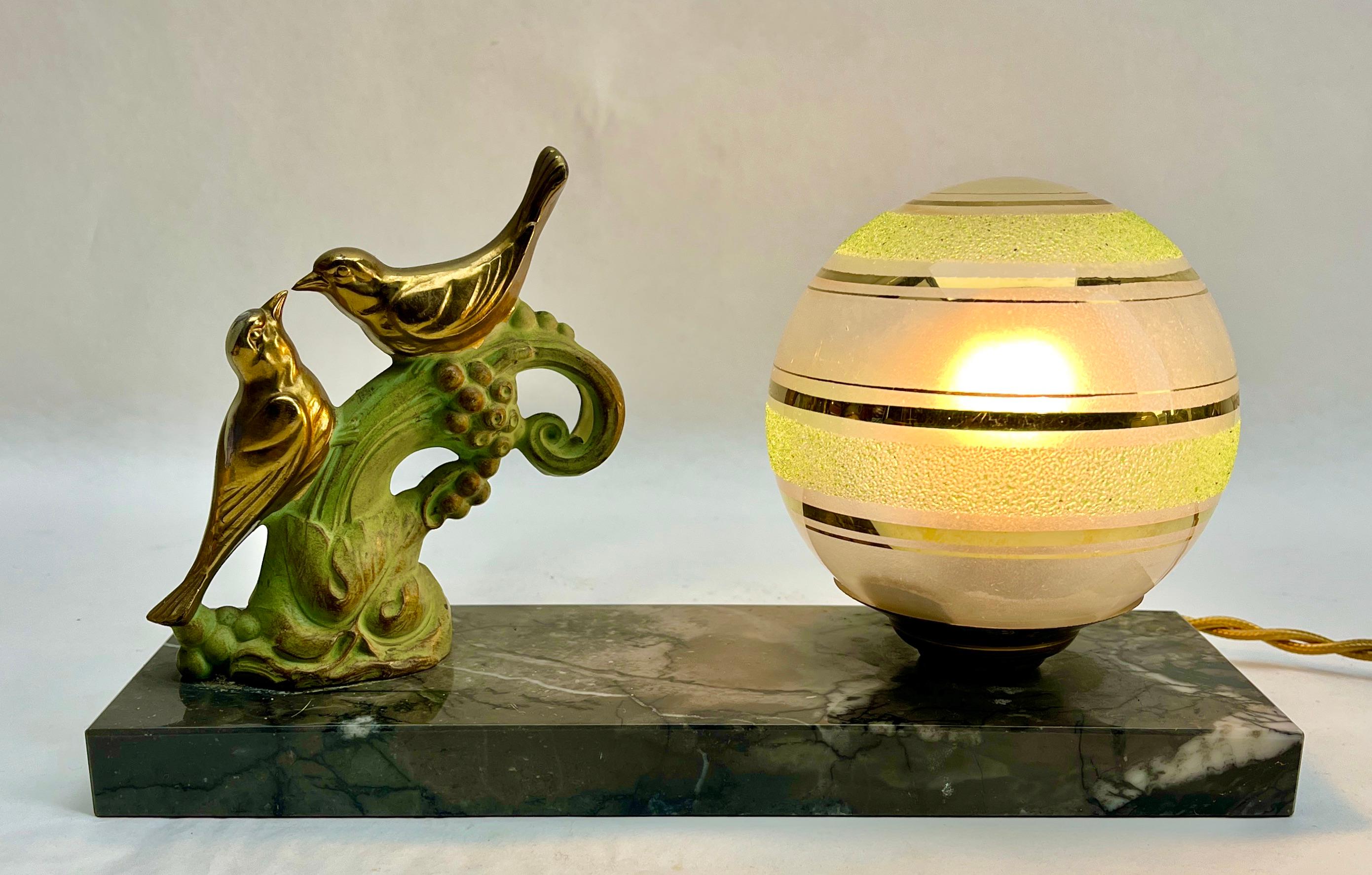 Stunning French Art Deco table lamp Gorgeous glass globe shade.
With Spelter Birds motif. Sitting on a marble base. 
In excellent condition and in full working order. 
Rewiring and New Fitting E14
Originel Patina on all Parts
The piece is in
