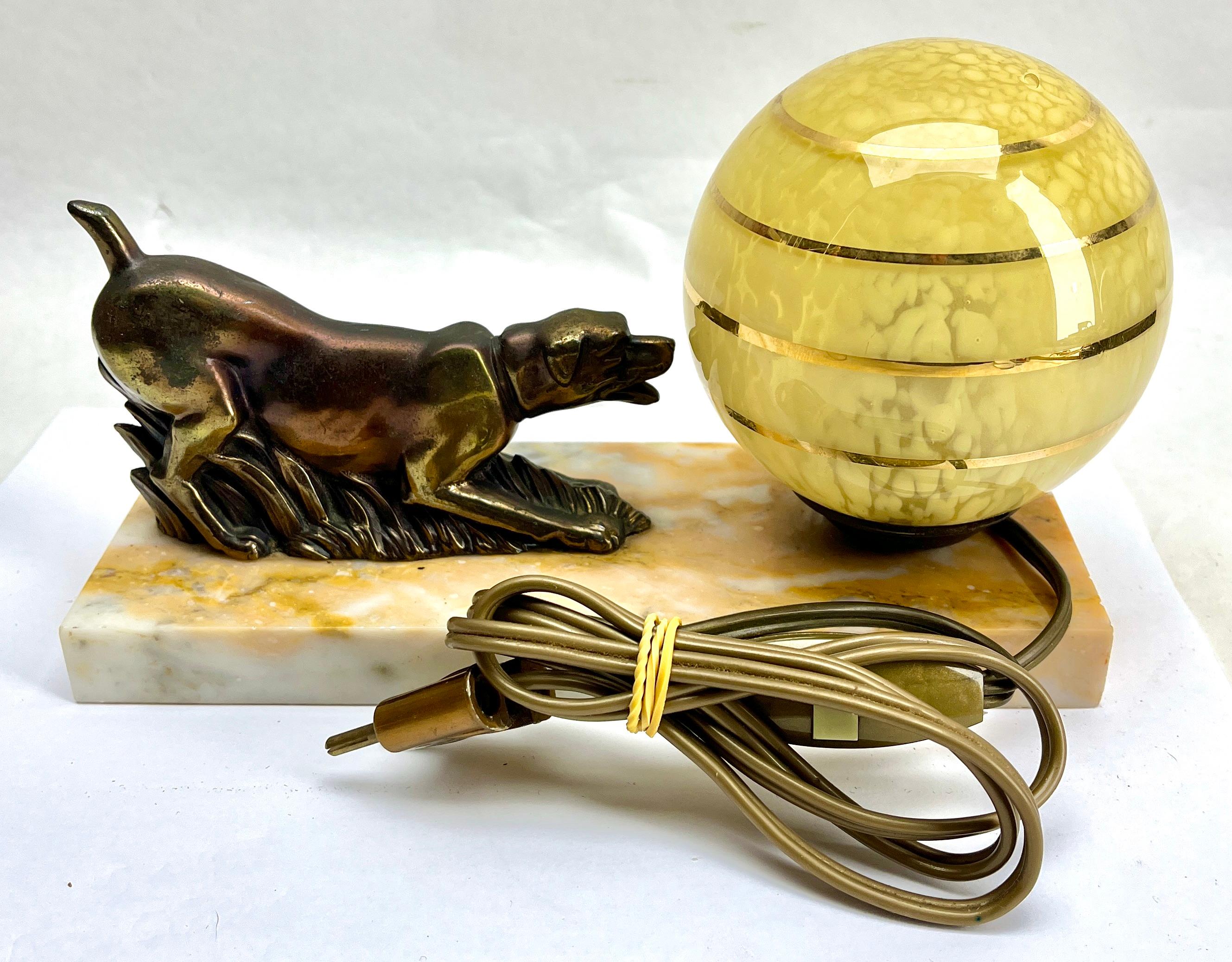 Stunning French Art Deco table lamp Gorgeous glass globe shade.
With Spelter Dog motif. Sitting on a marble base. 
In excellent condition and in full working order. 
Rewiring and Fitting E14
Originel Patina on all Parts
The piece is in excellent and